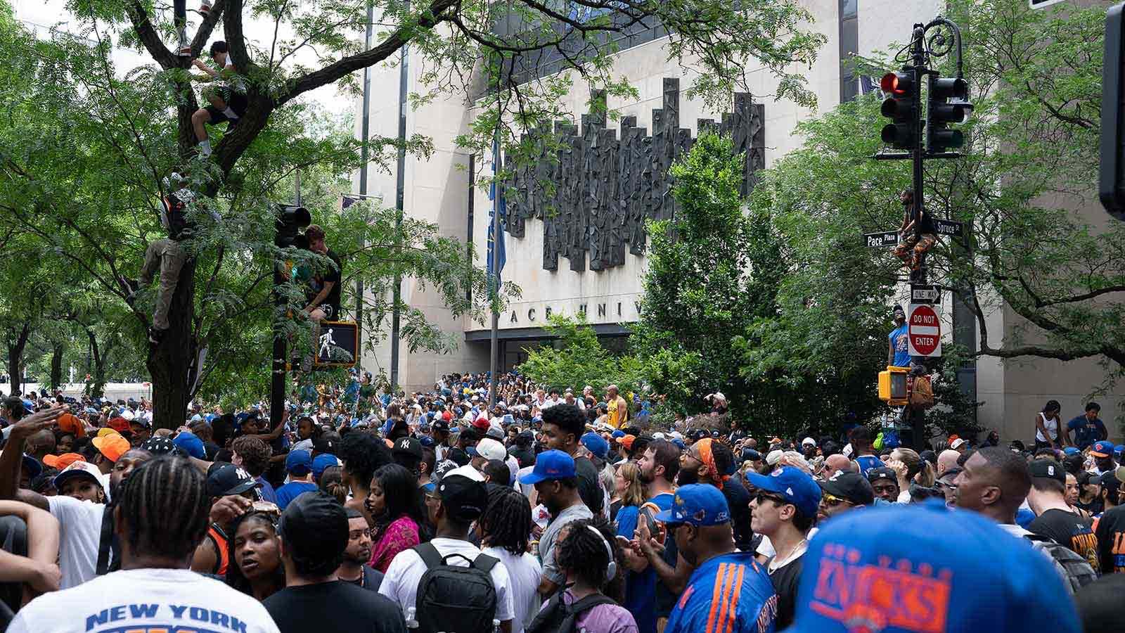 Knicks fans swarm the area around One Pace Plaza, even climbing signs