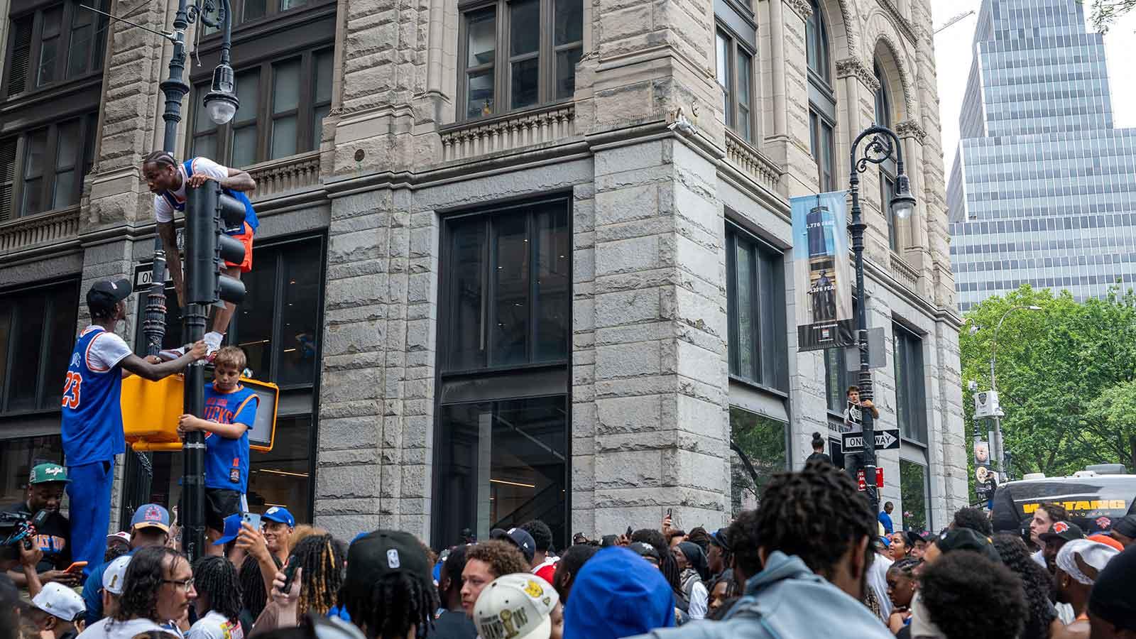 Knicks fans climb street signs outside 41 Park Row
