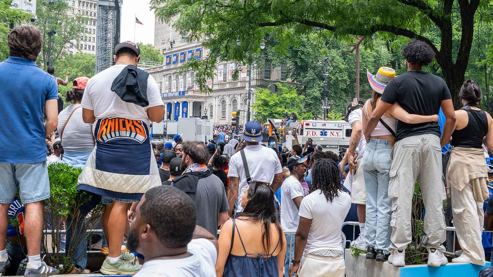 A crowd of Knicks fans watch City Hall from afar 