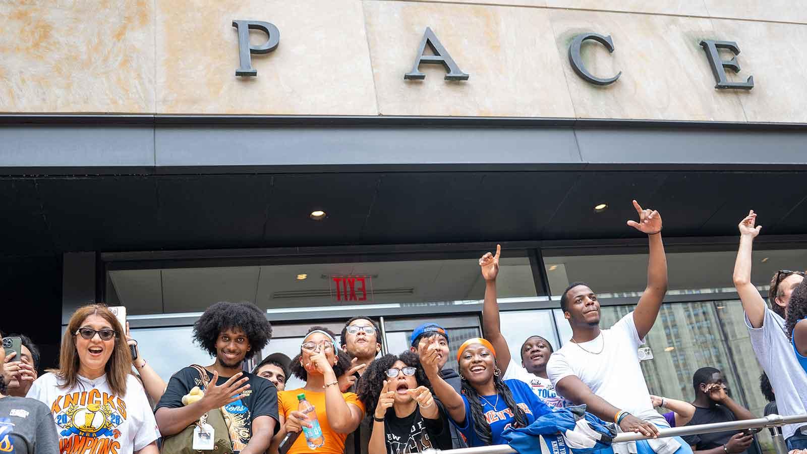Knicks fans wave at the camera outside of One Pace Plaza