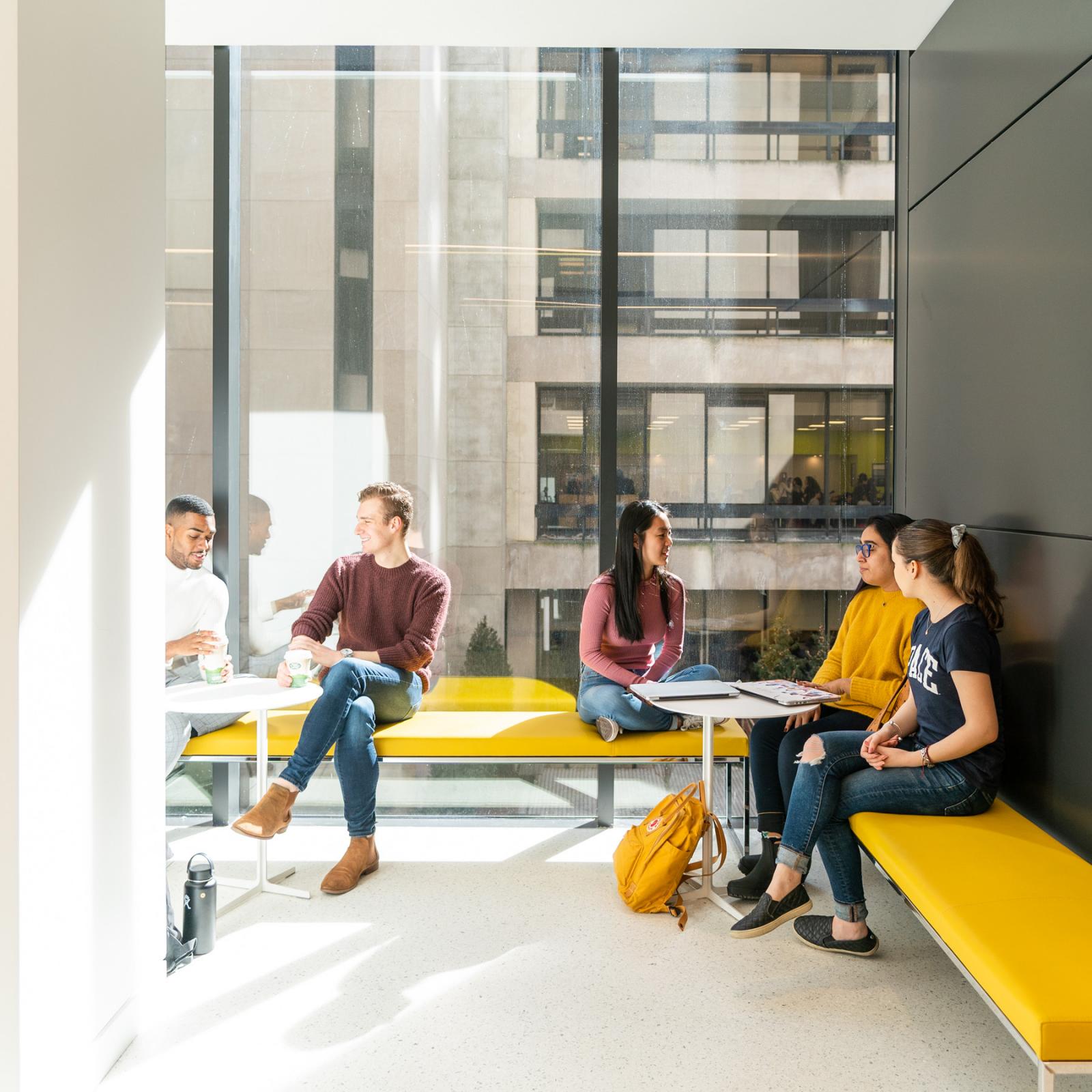Students sitting in an open seating area at the NYC campus.