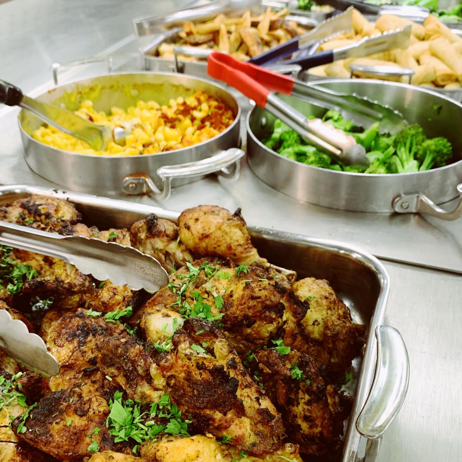 Buffet with different pots filled with food.