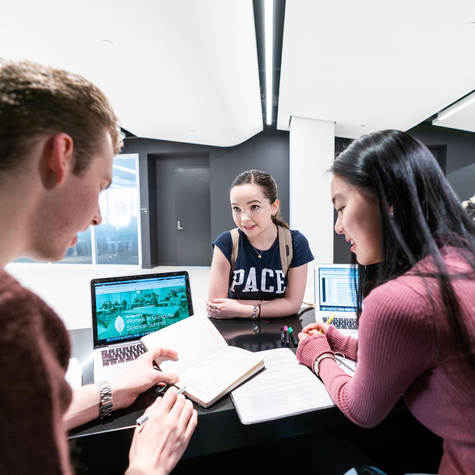 Students studying together in front of computers.