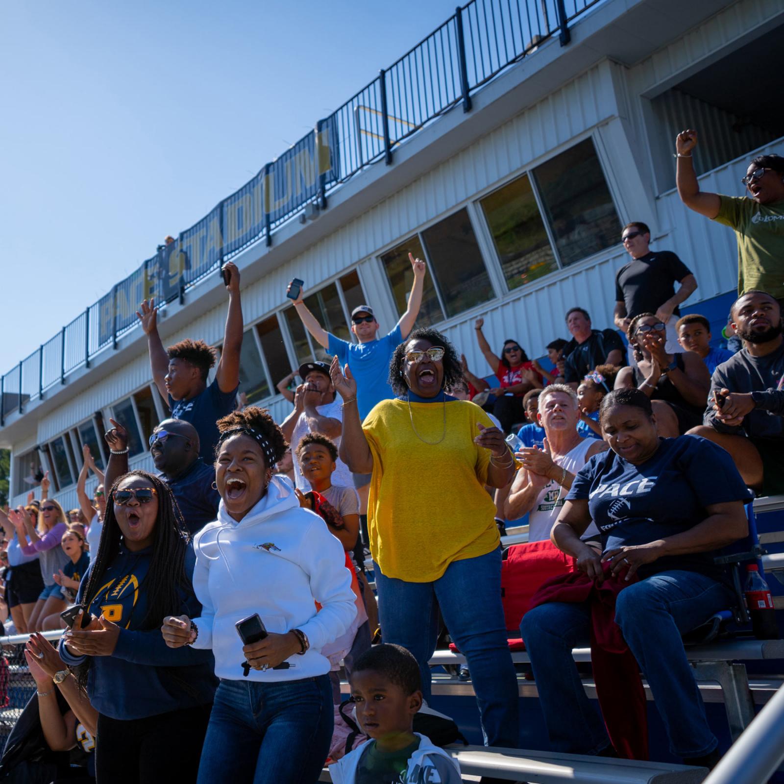 Students cheering at a football game.