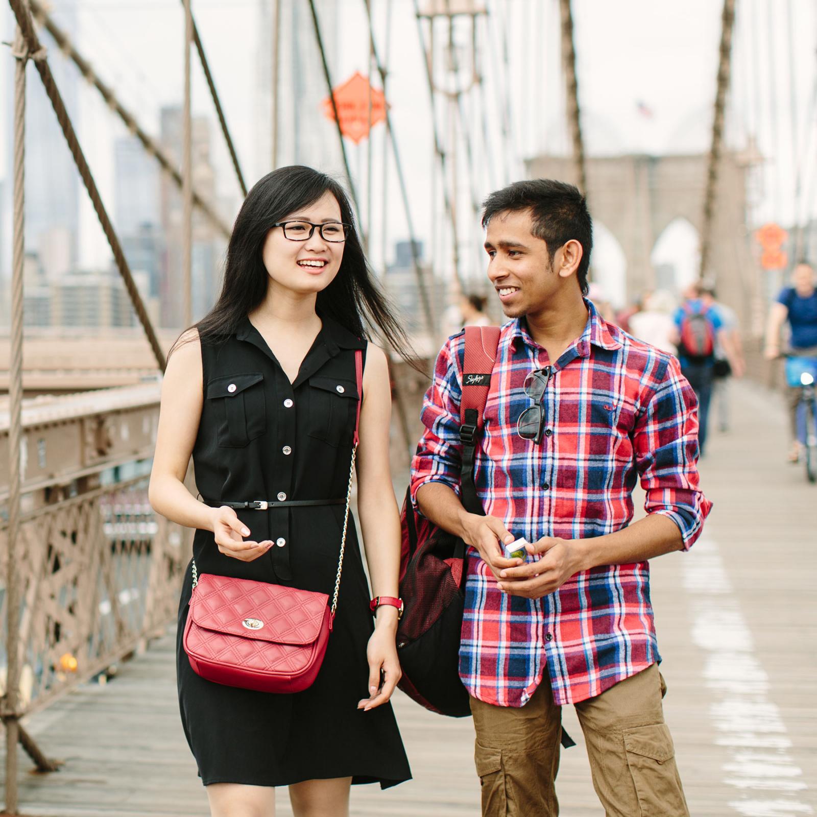 Two Pace University students walking across the Brooklyn Bridge
