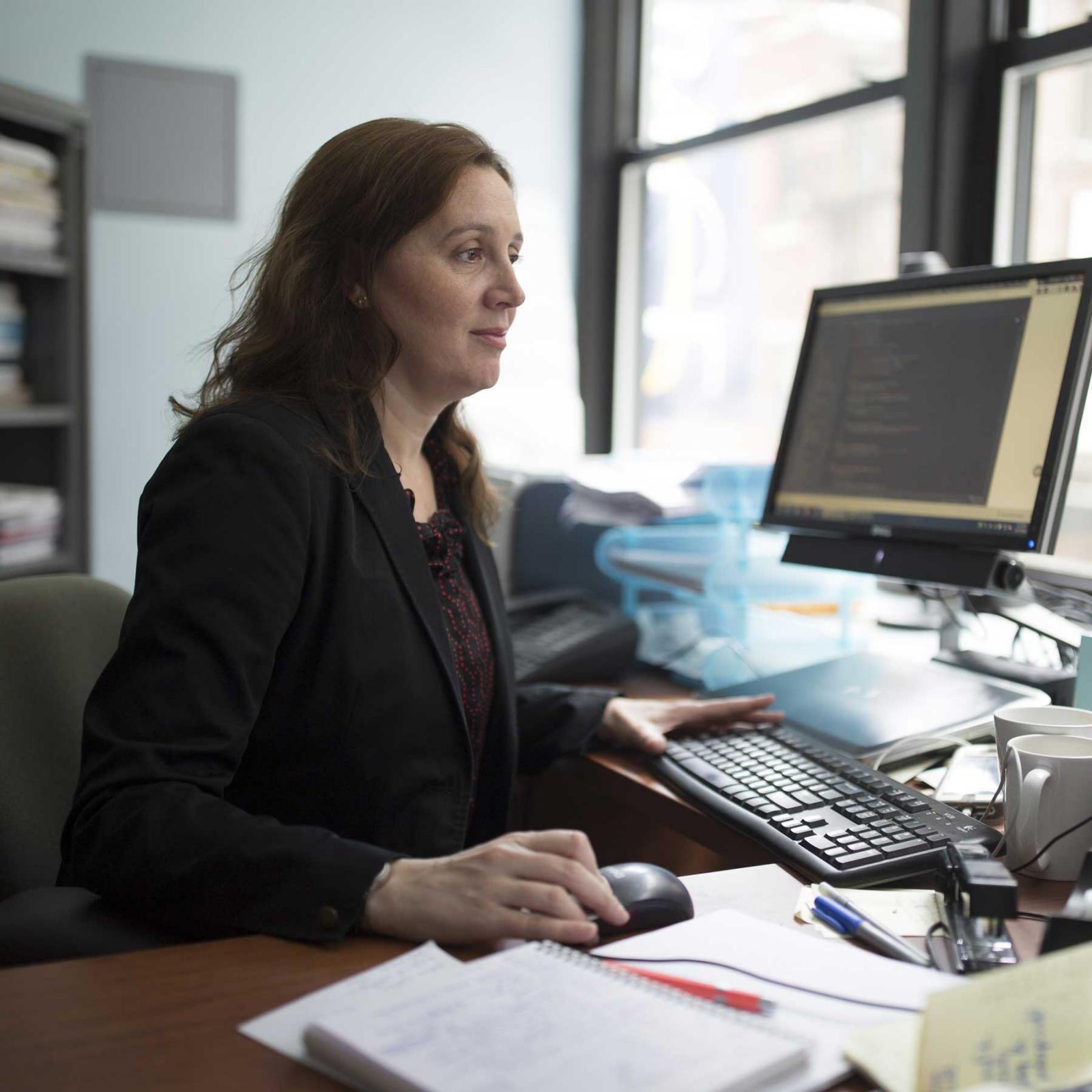 Faculty member working at her desk.