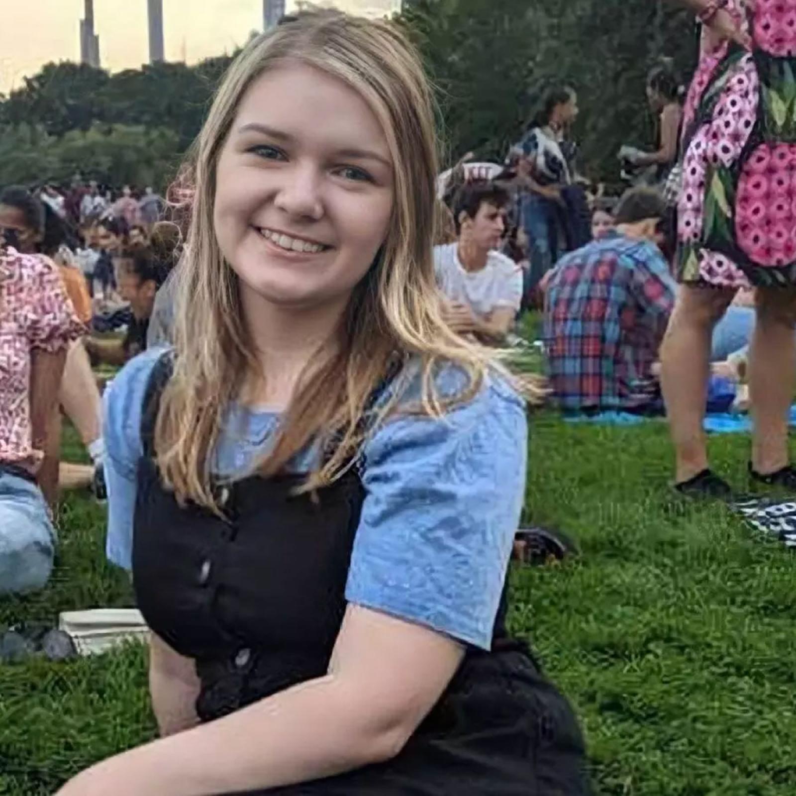blonde girl sitting on the grass