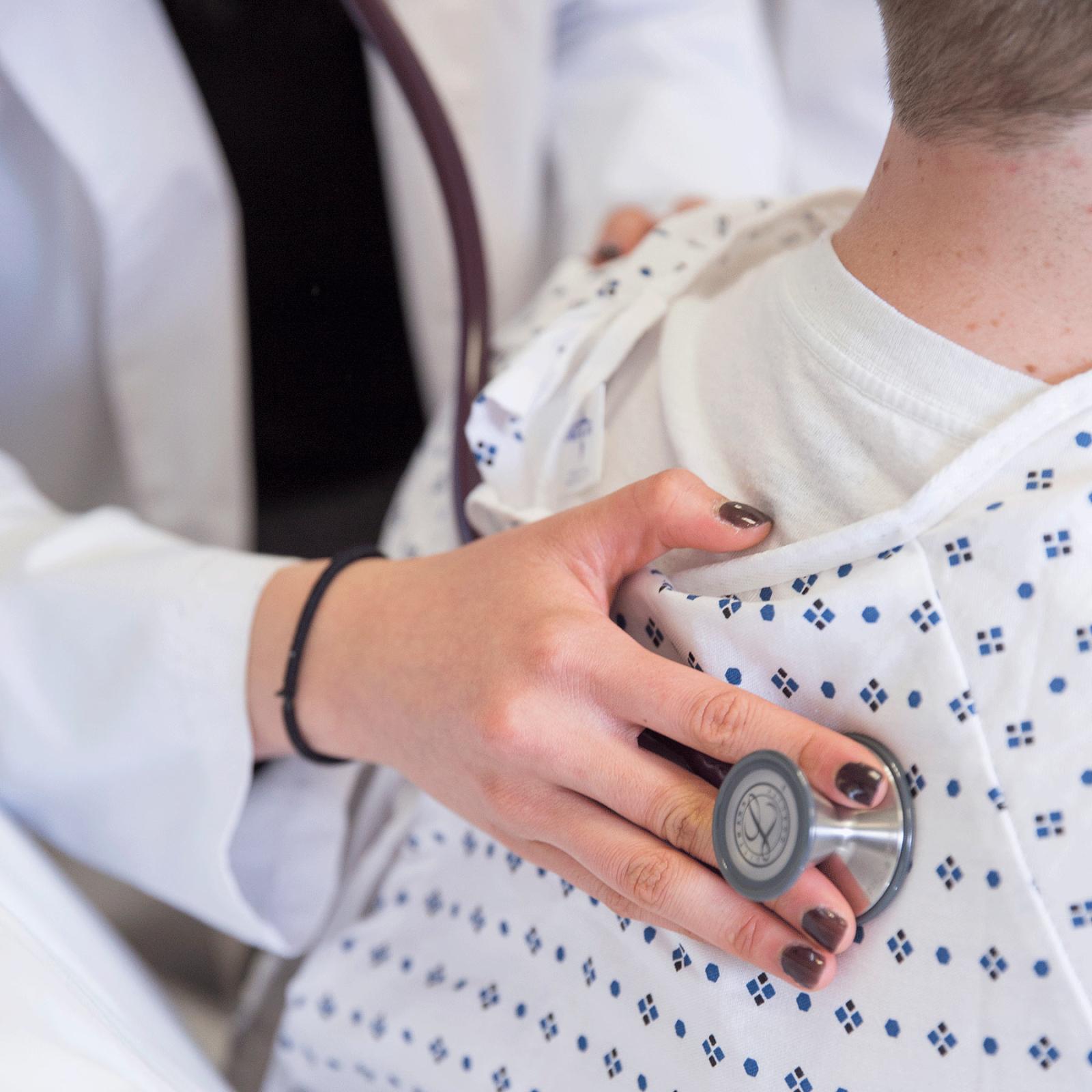 Physician Assistant student listening to a patient's heart.