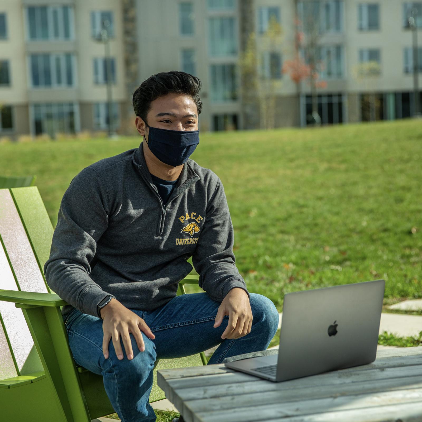 Pace student sitting in front of a laptop