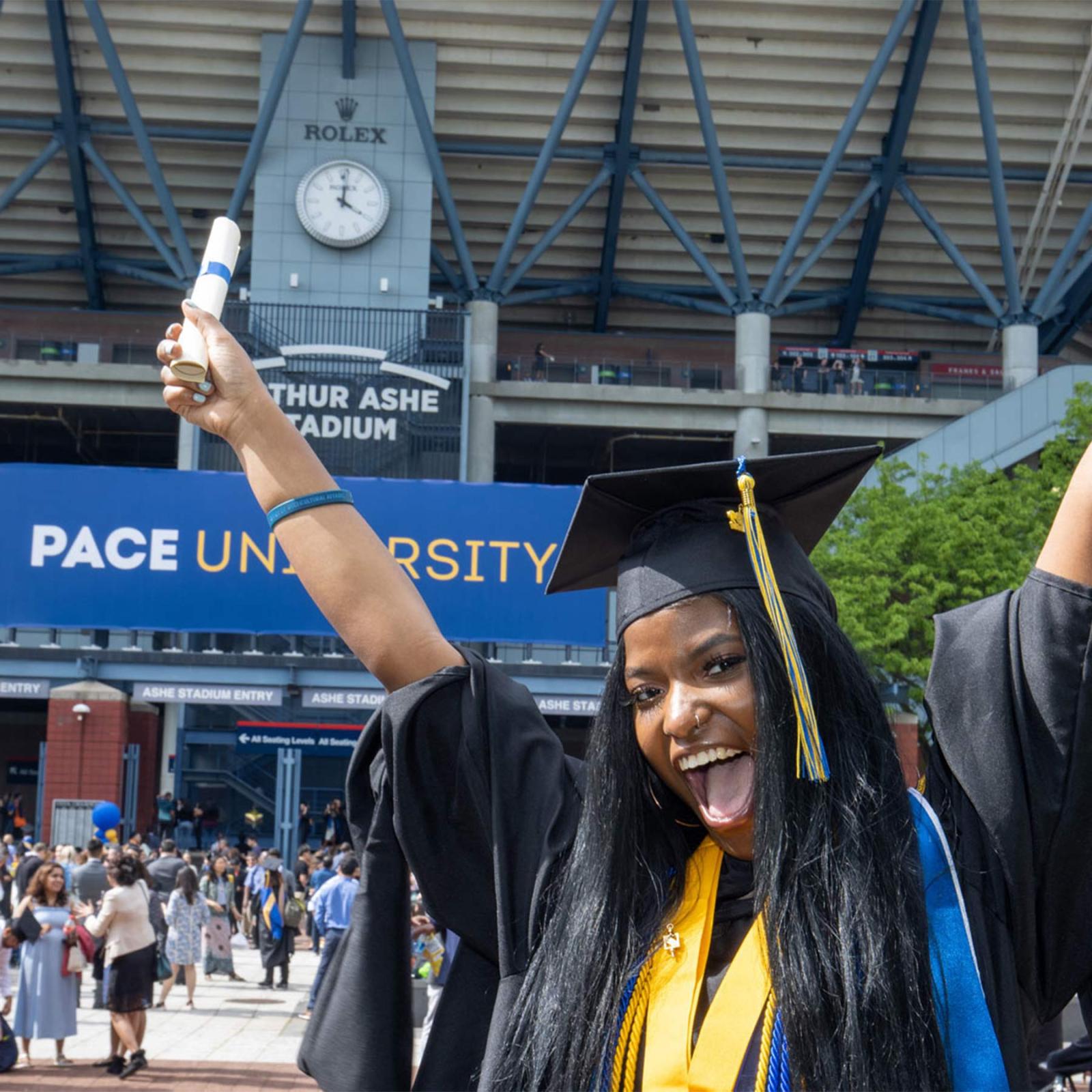women smiling at camera in her graduation regalia