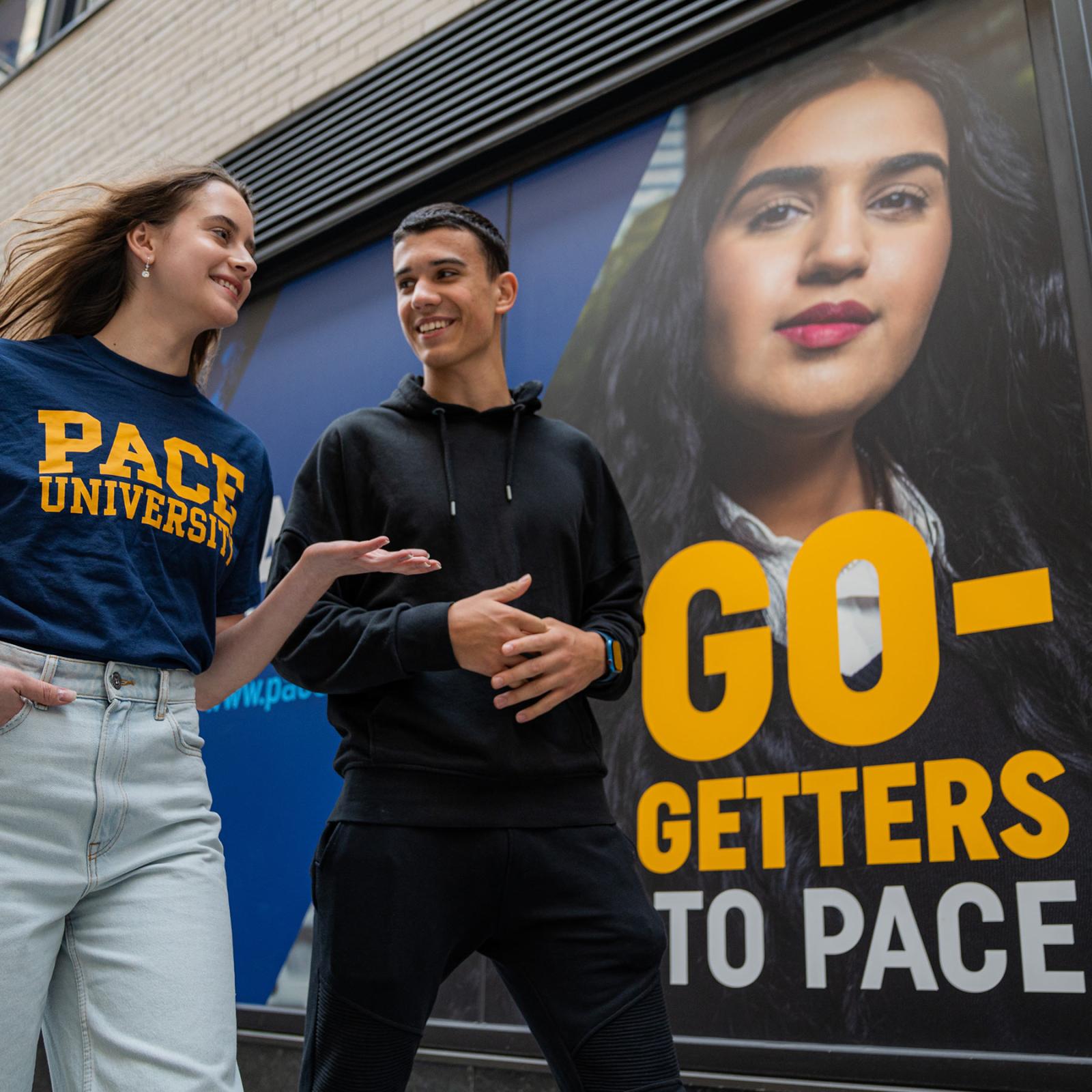 Two Pace students walking in front of 1 Pace Plaza in NYC.