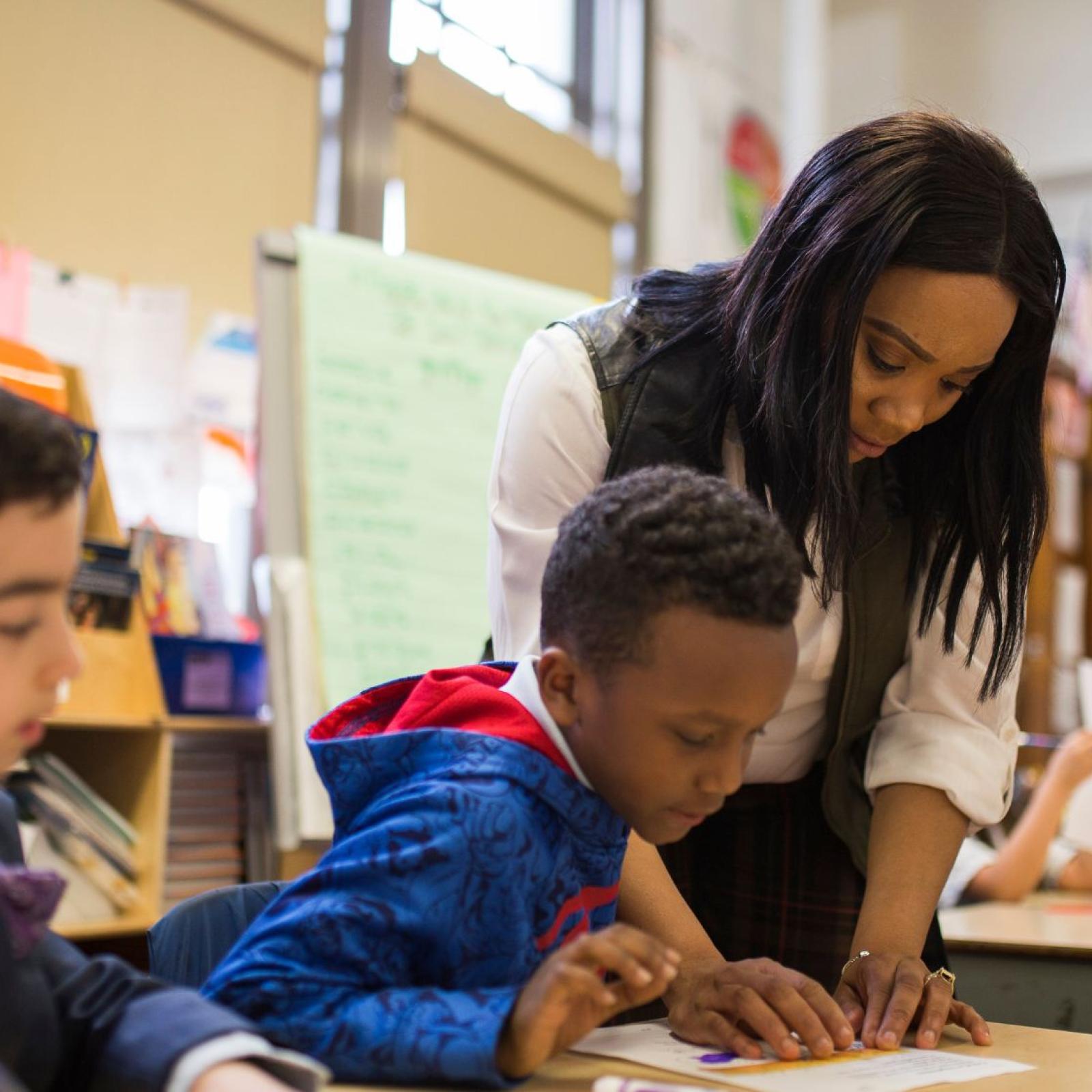 teacher working with a student in a classroom