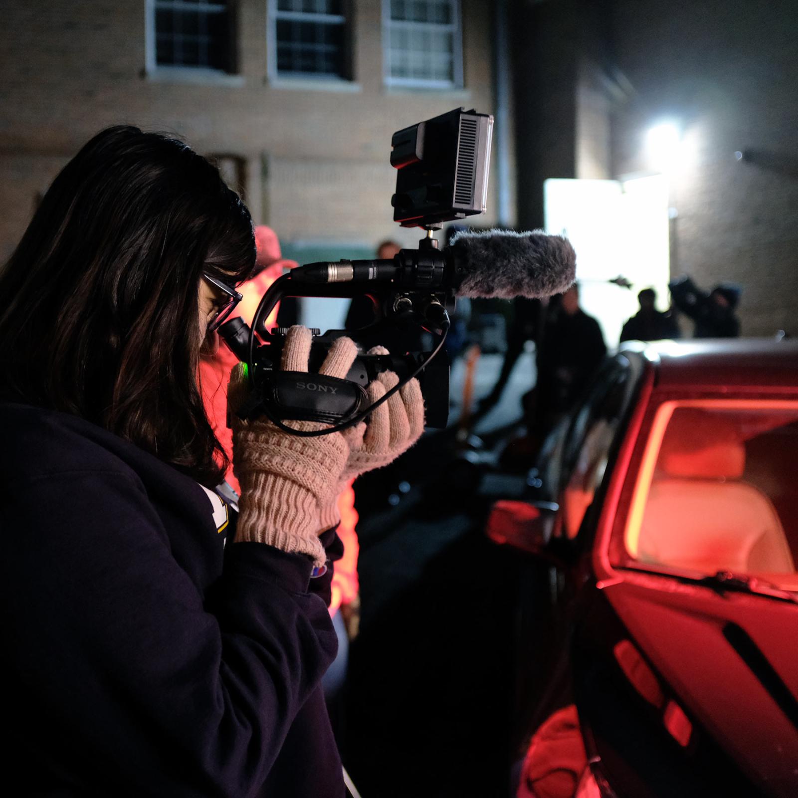 Pace University's Media, Communications, and Visual Arts student filming in low lighting