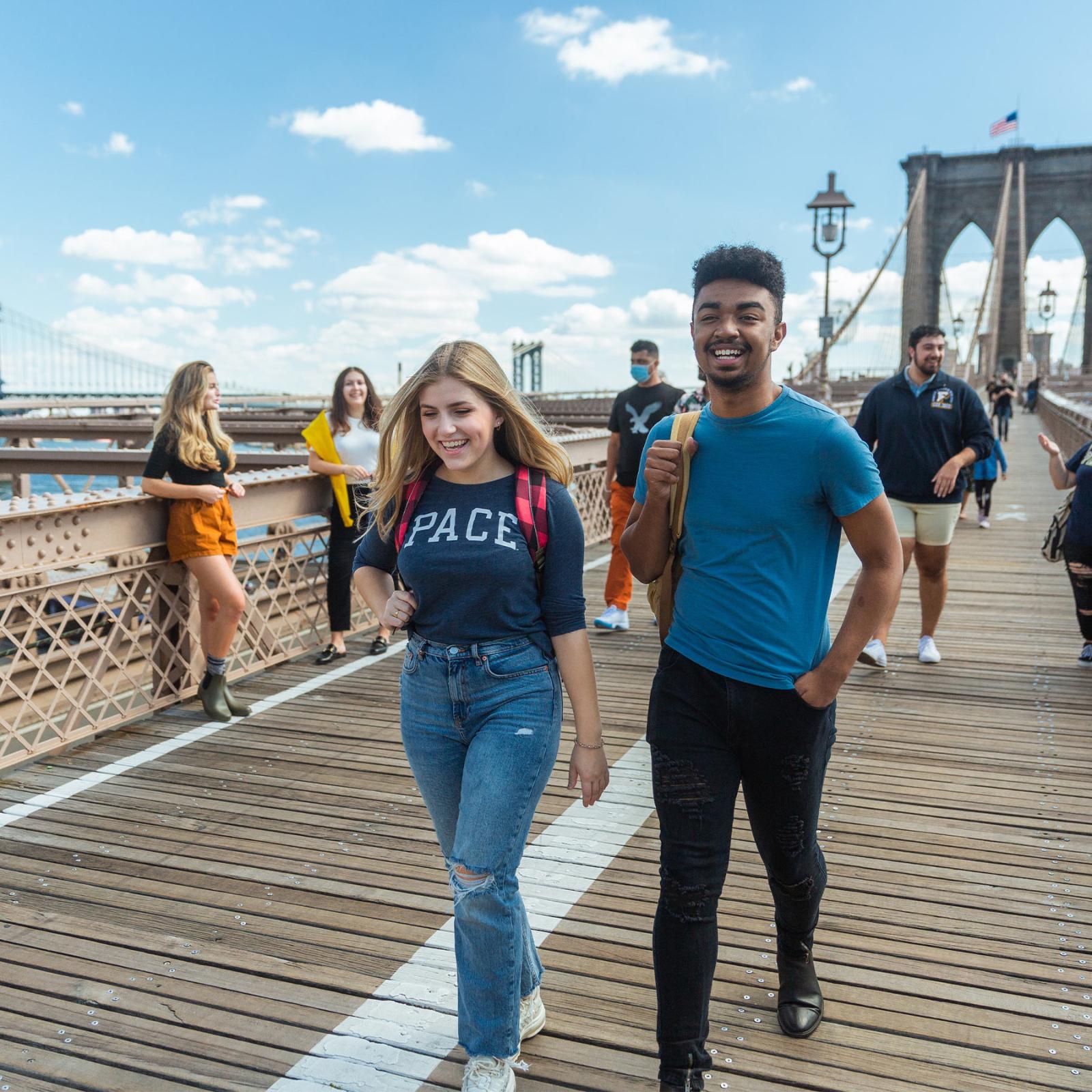 Two Pace students walk along the Brooklyn bridge