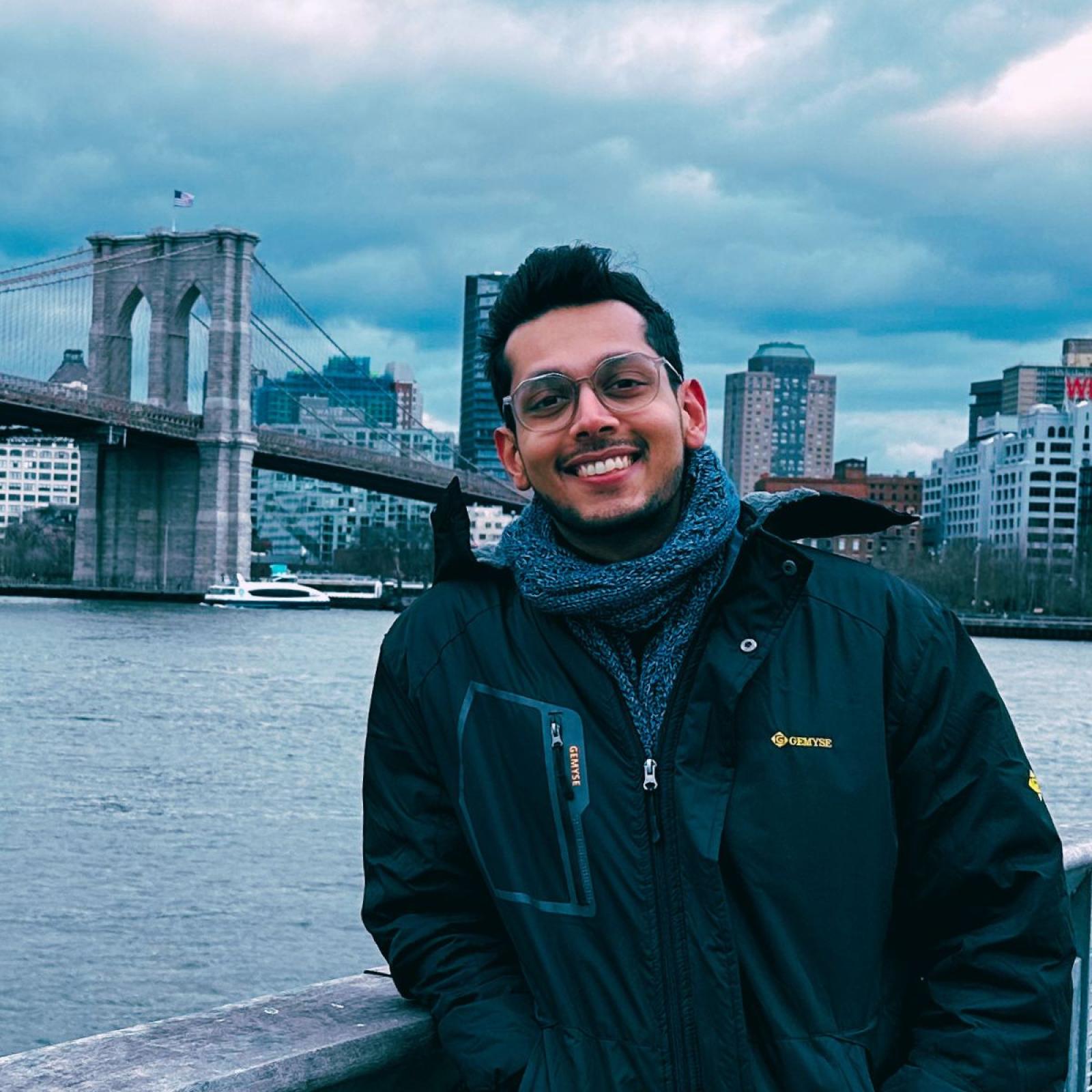 Image of Seidenberg student Nishant Doshi on a cloudy day with the Brooklyn Bridge in the background