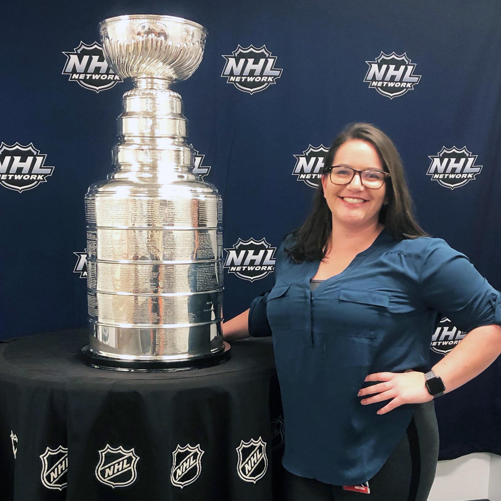 Pace University's Media, Communications, and Visual Arts alum Kelly Writenour posing with the NHL Stanley Cup