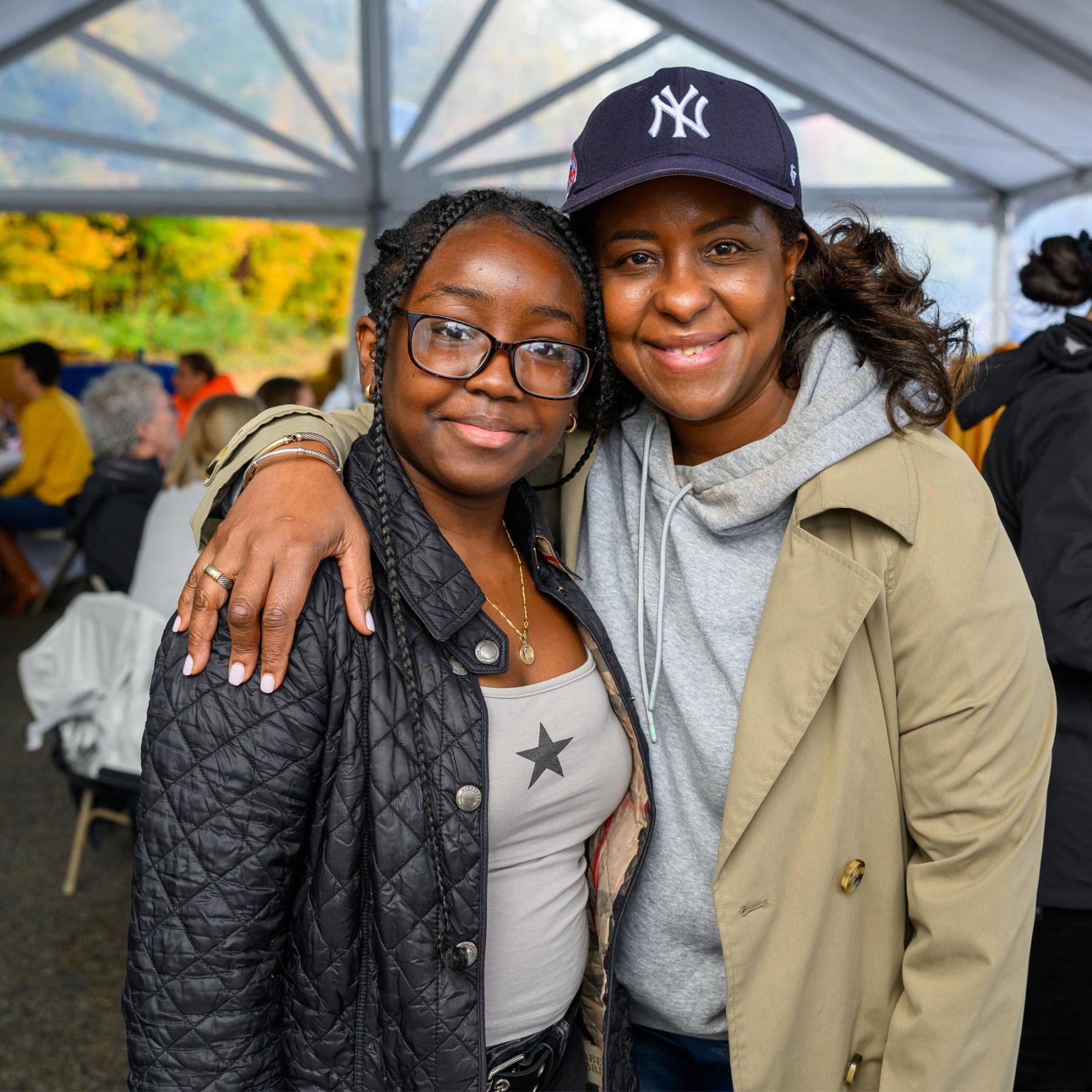 two Pace alumnae with their arms around each other posing for the camera