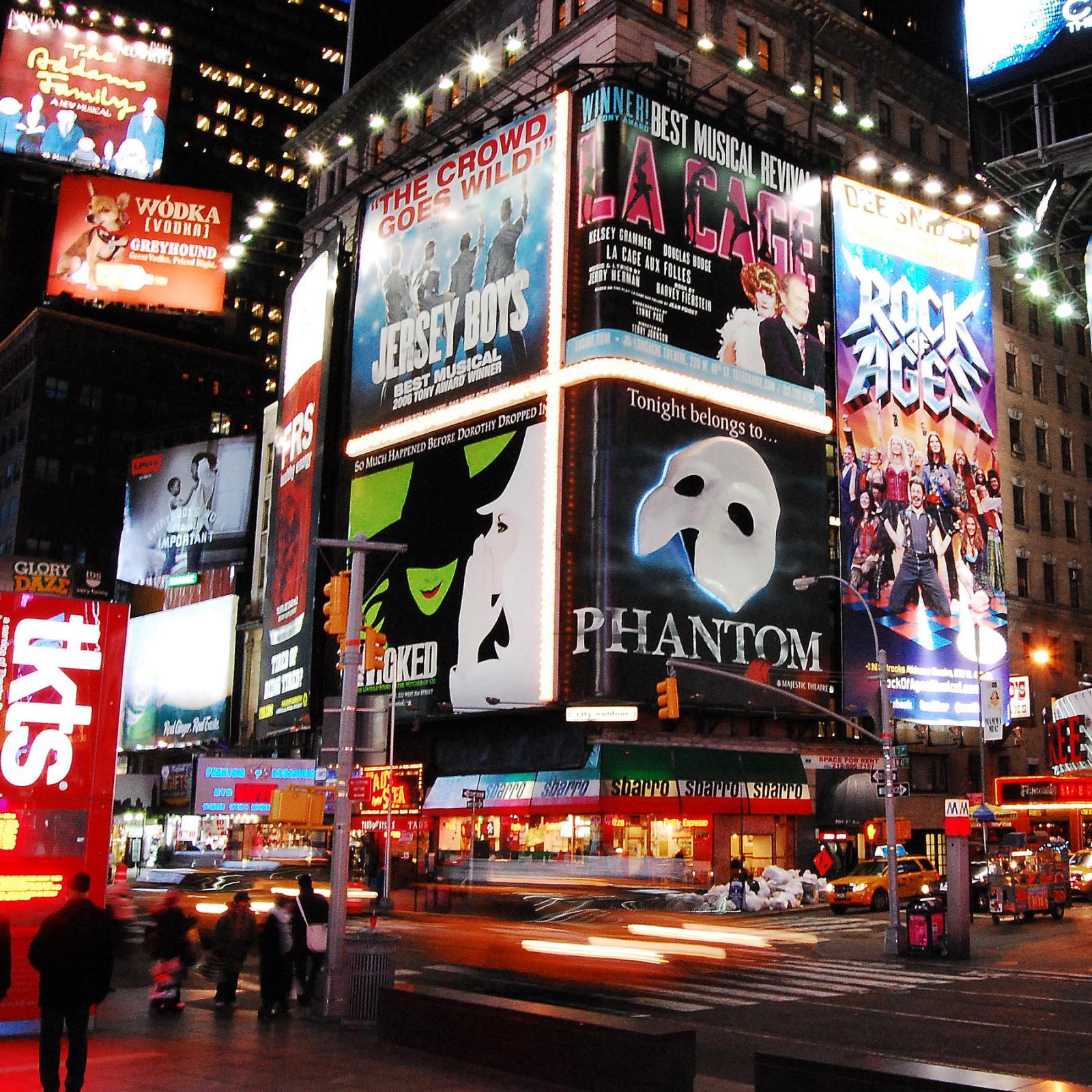 NYC and Broadway at night with marquees for major Broadway performances.