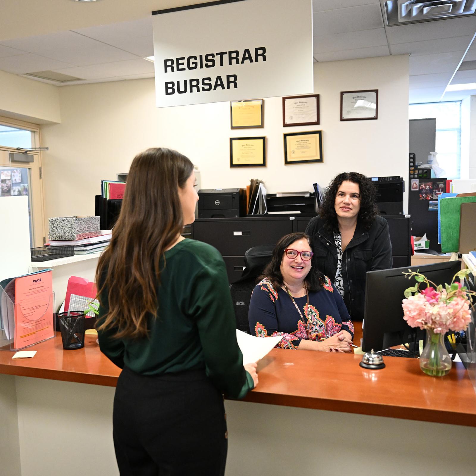 Student at the front desk of the Elisabeth Haub School of Law Registrar and Bursars office.