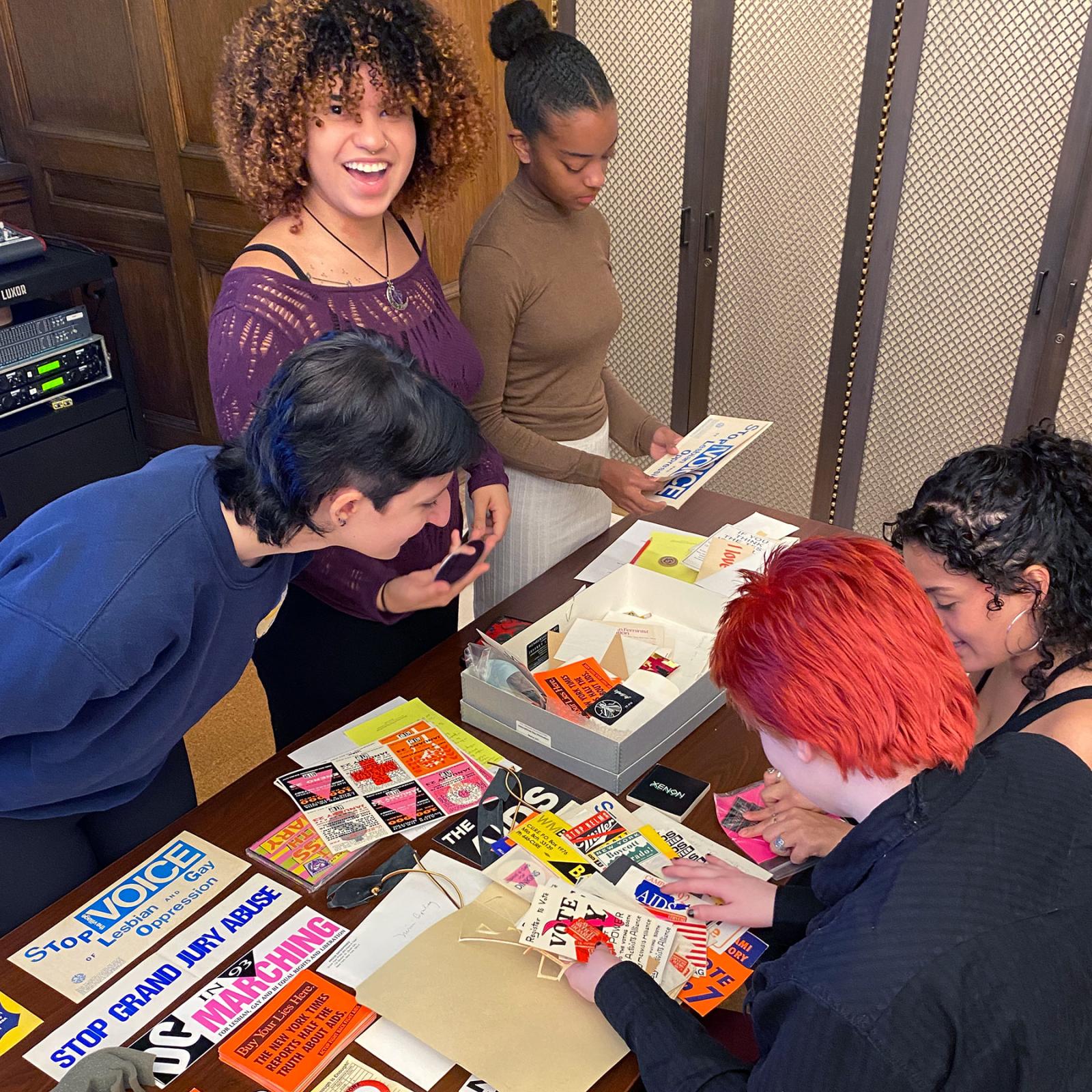 Several Pace University Women's and Gender Studies students looking over protest and advocacy materials