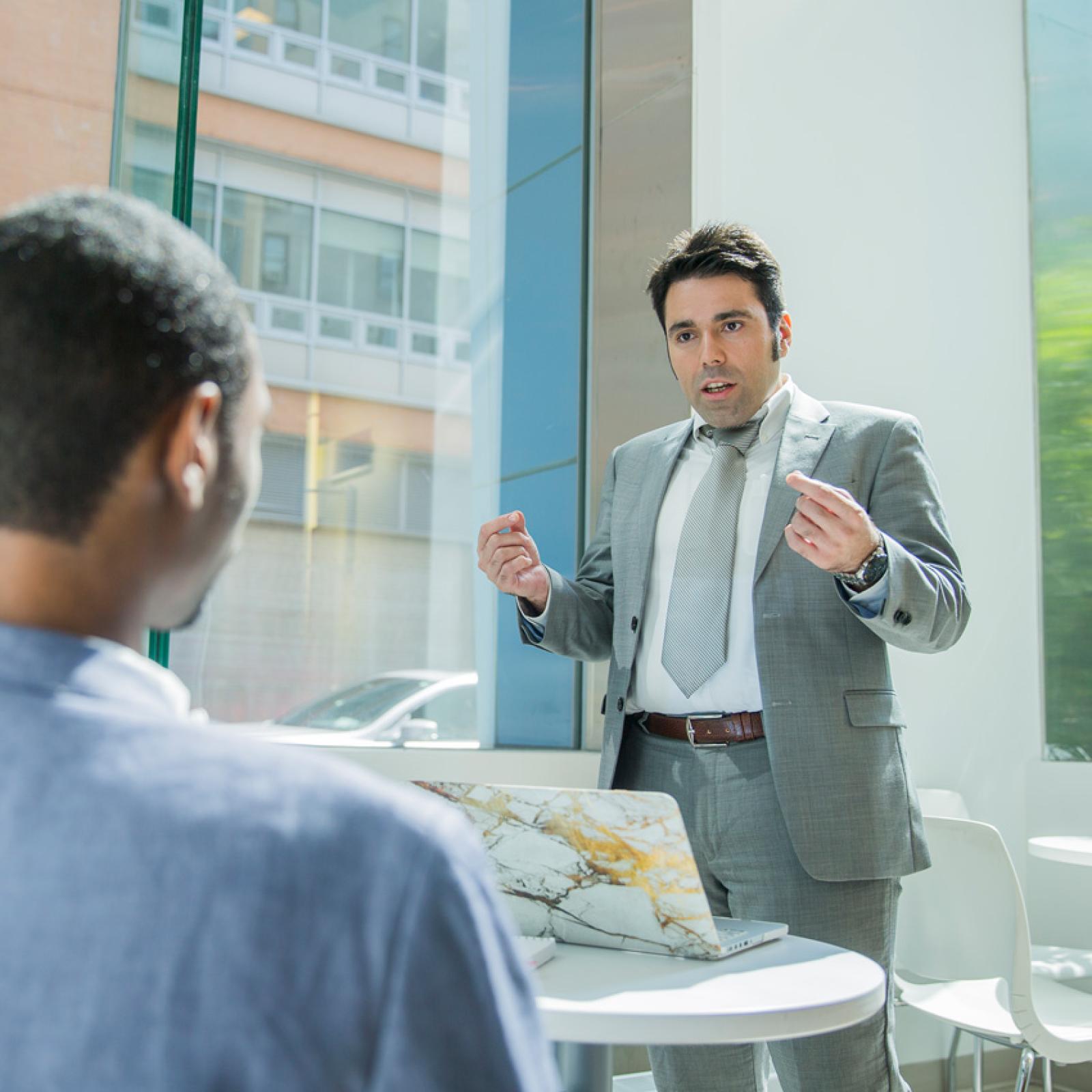 Two men in suits talking.