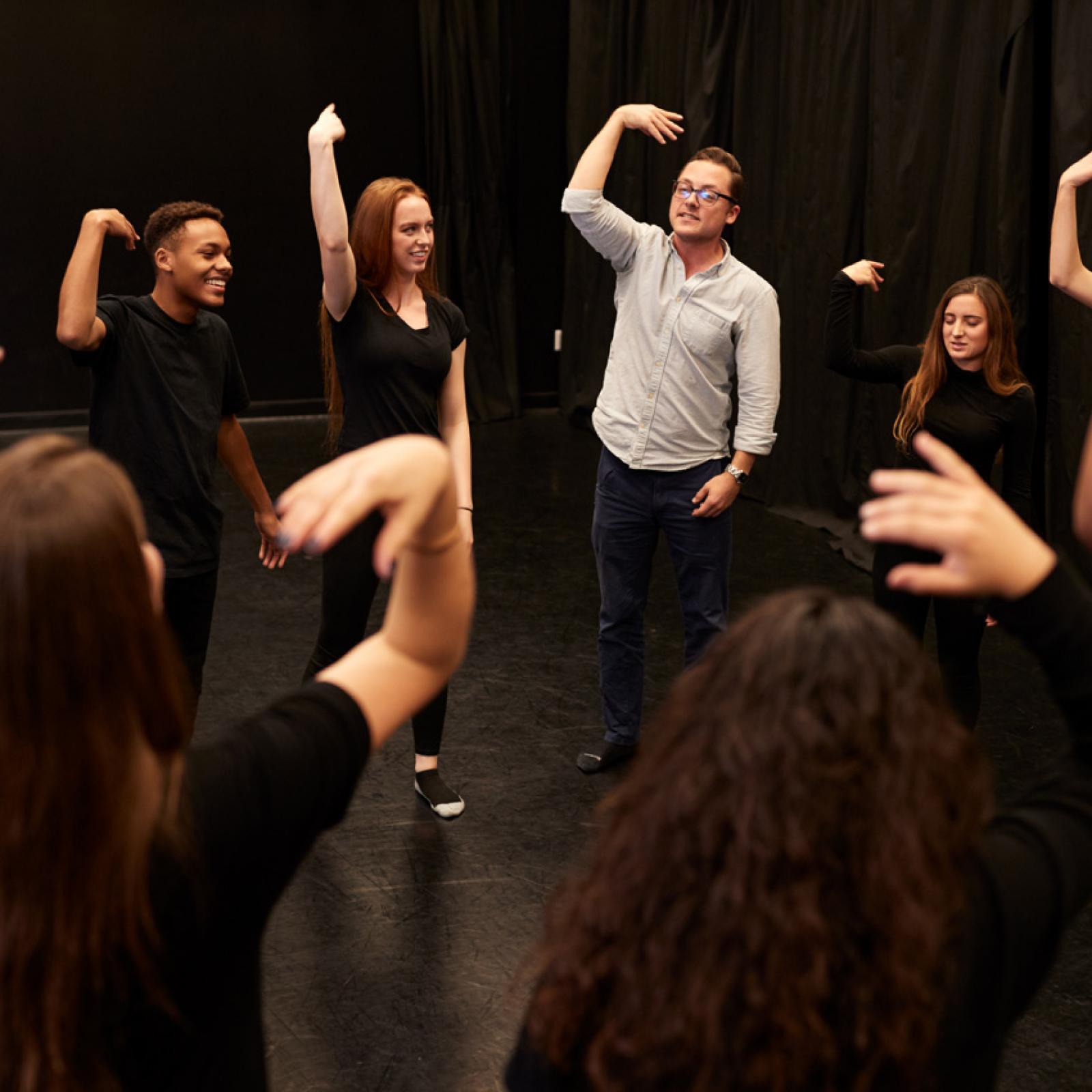 A theater teacher working with students in a movement exercise at Pace University.