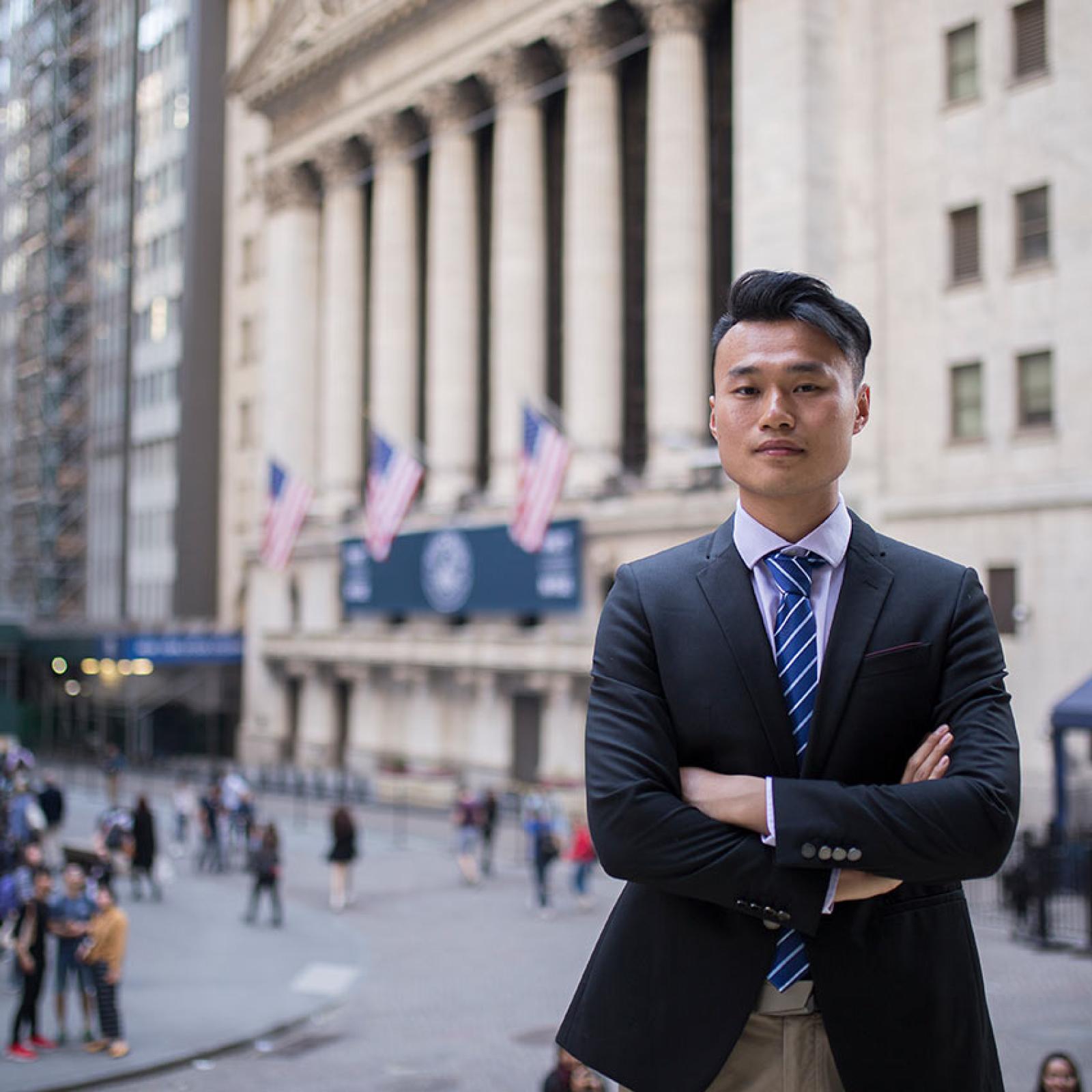 A Pace University student stands with arms crossed in downtown NYC