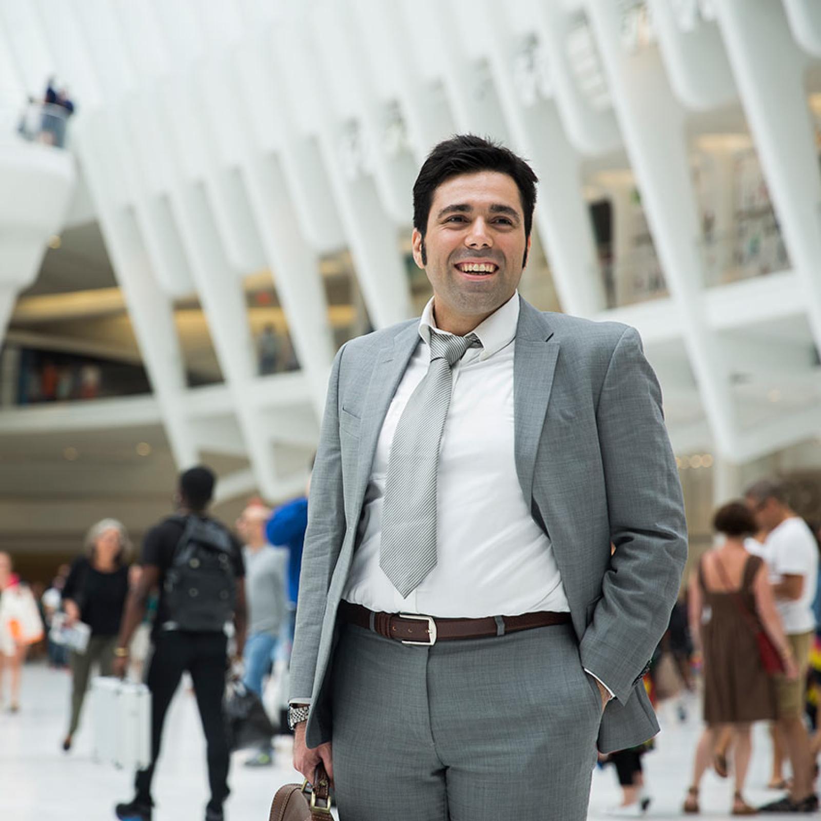 A Pace student wears a grey suit in the occulus