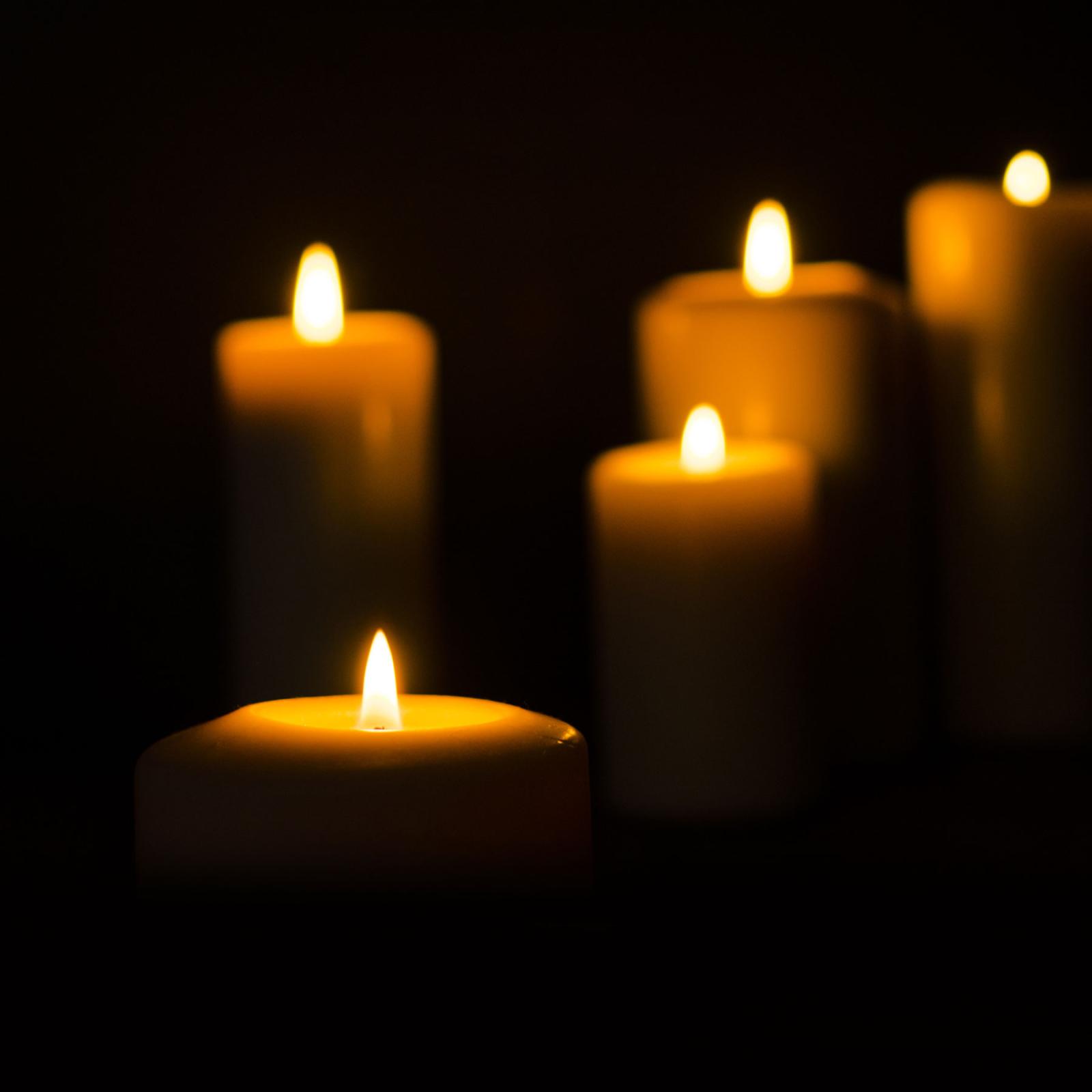 Lighted candles against a black background.