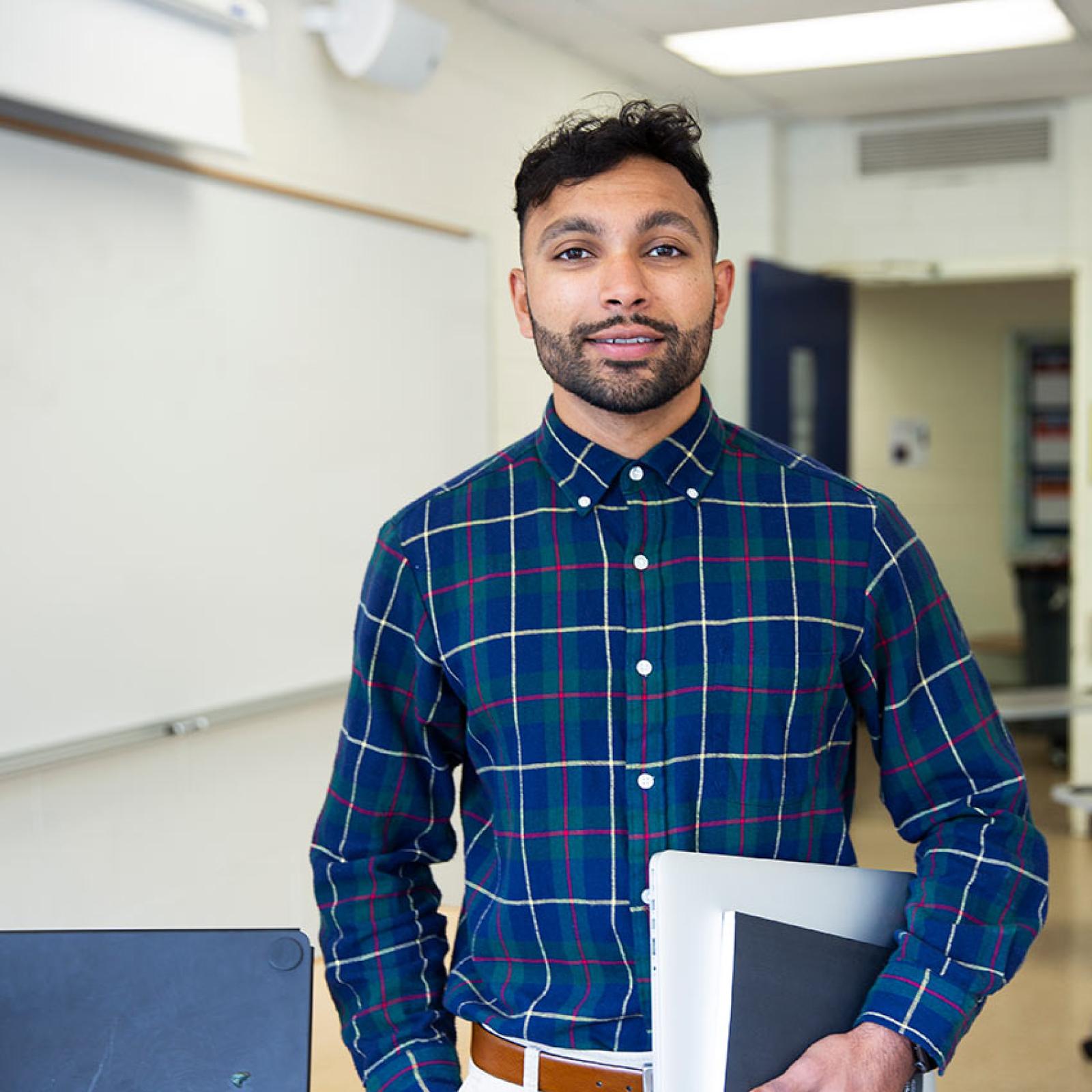 A Pace University student teacher stands in a classroom.