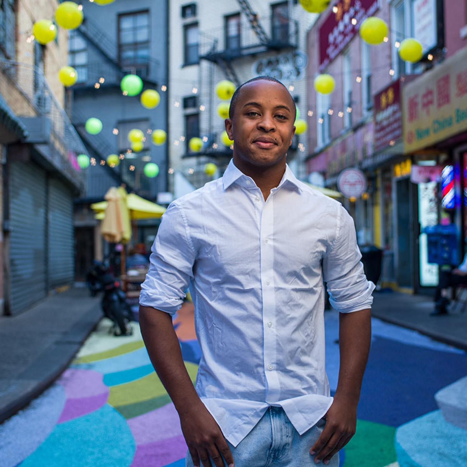 A Pace University student stands in the middle of a colorful Chinatown street