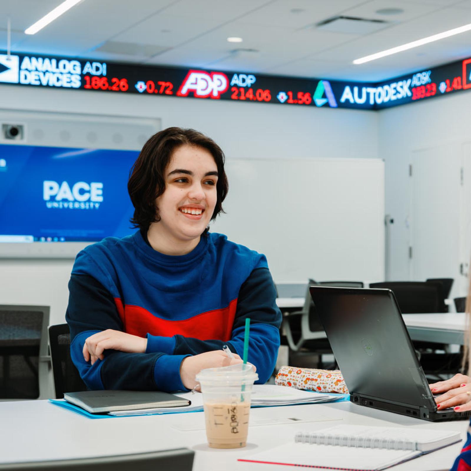Pace University student in a business classroom.