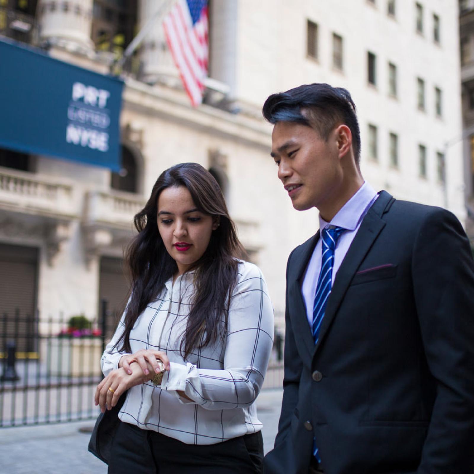 Two Pace University business students walking near Wall Street.