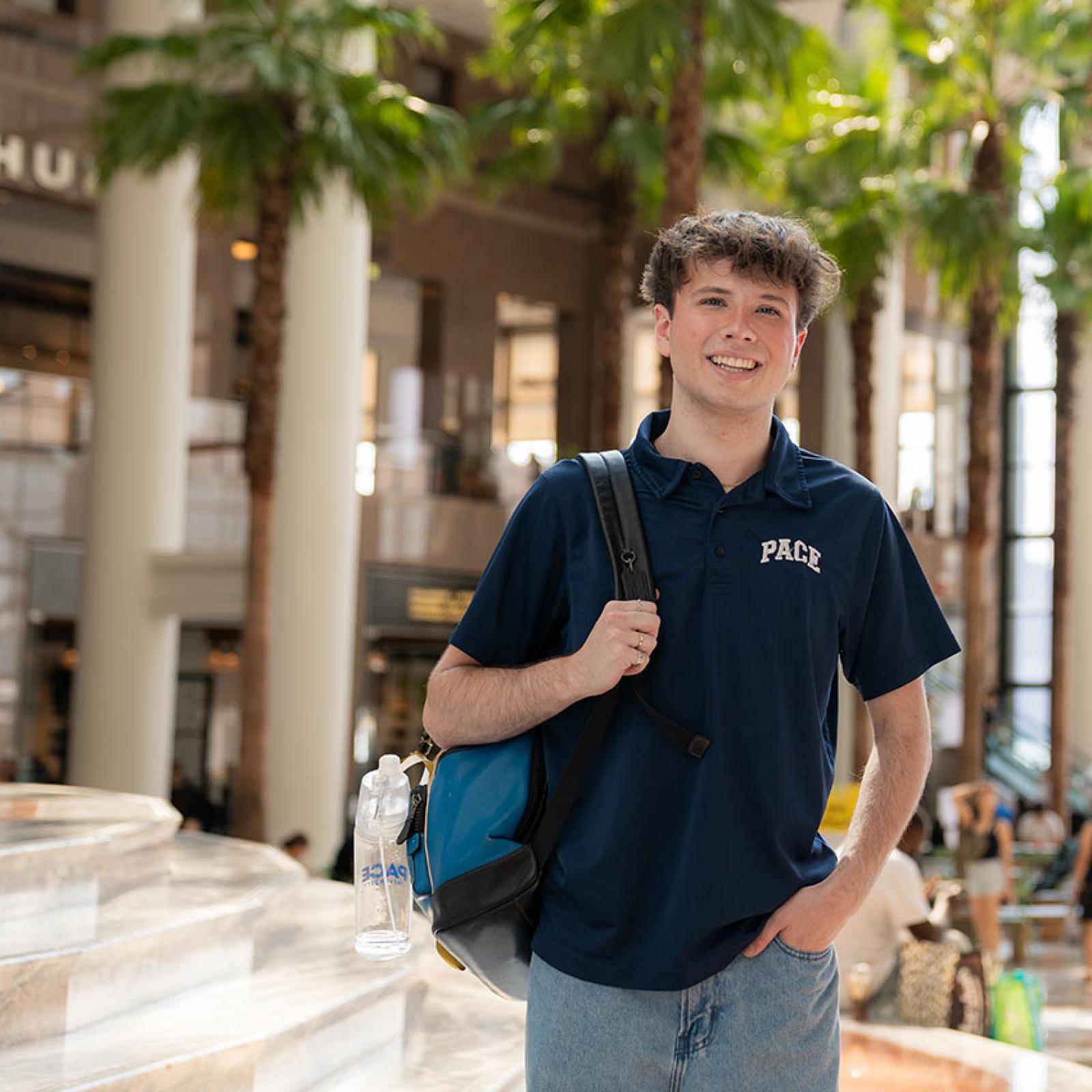 A Pace student wearing a backpack smiles 