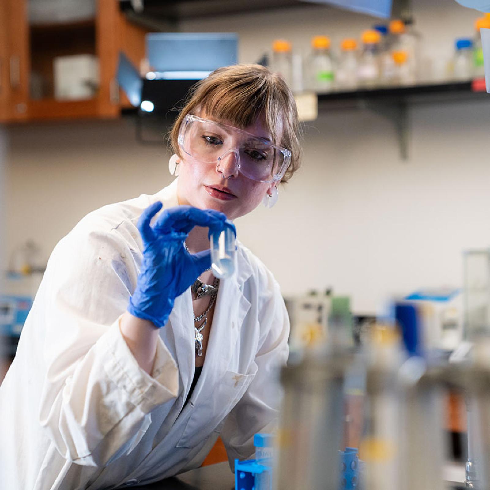 A Pace University student examines a sample in a lab.