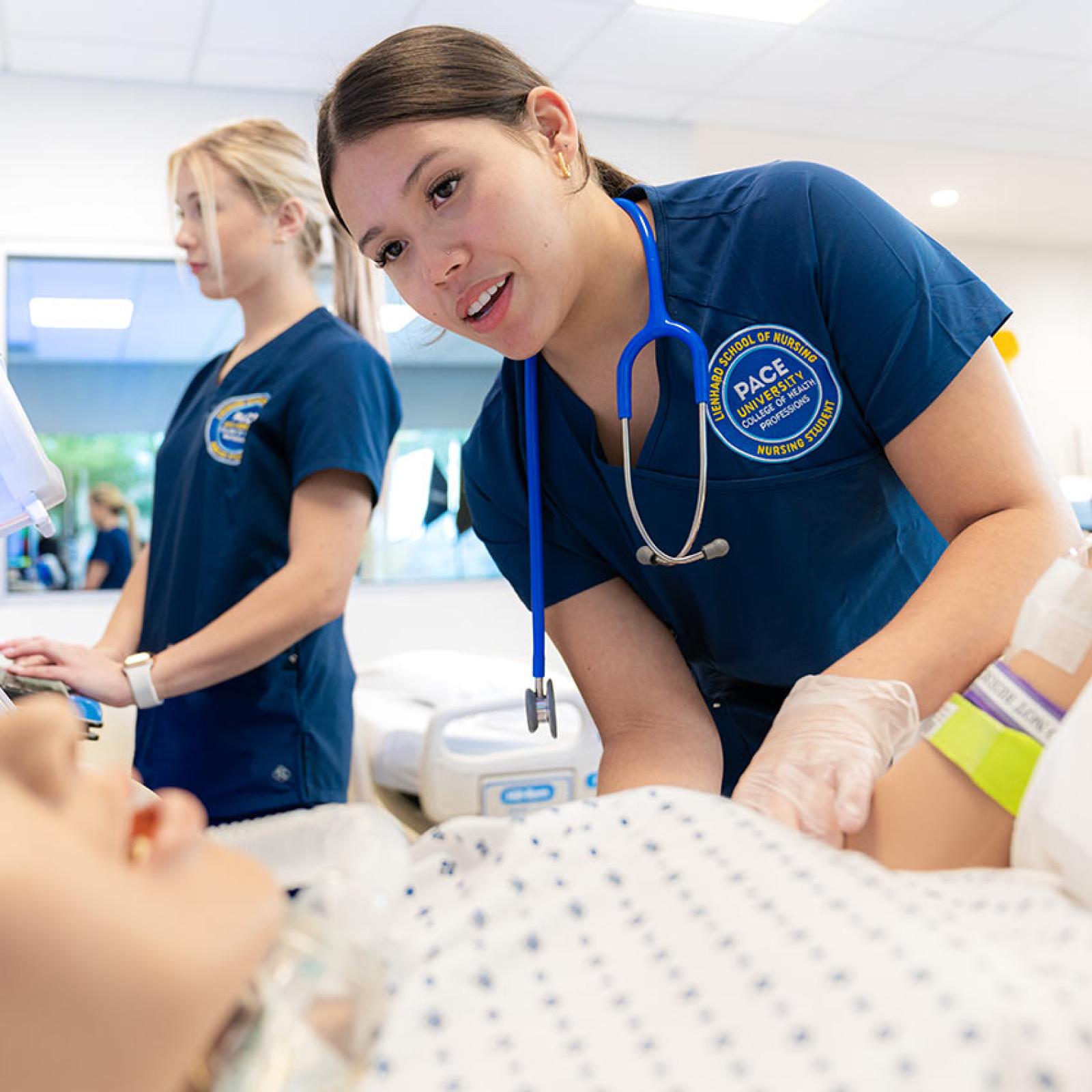 Nursing student from Pace University's College of Health Professions practicing techniques on a simulated dummy.