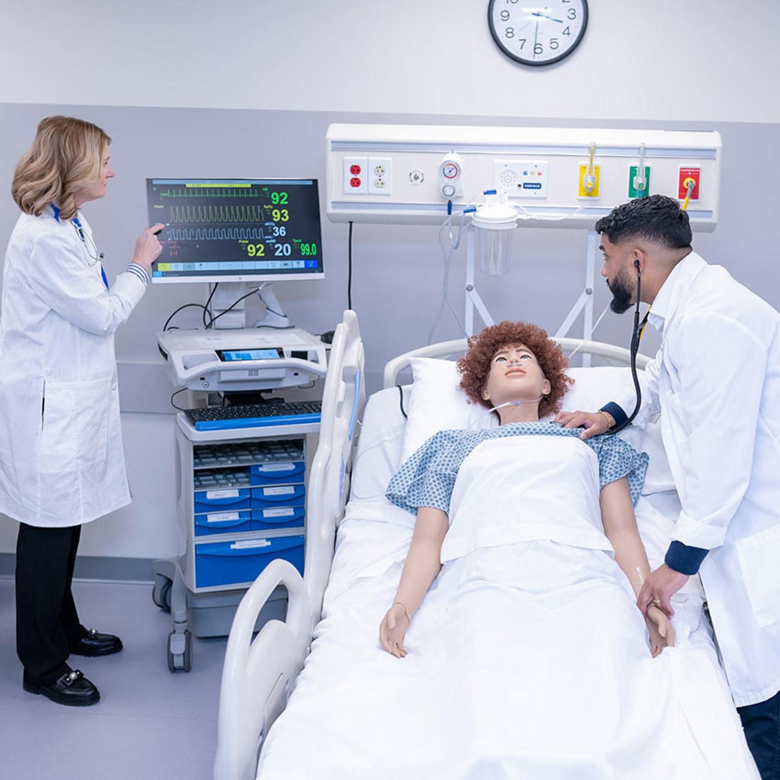 A student and professor from Pace University's College of Health Professions practicing on a manikin.