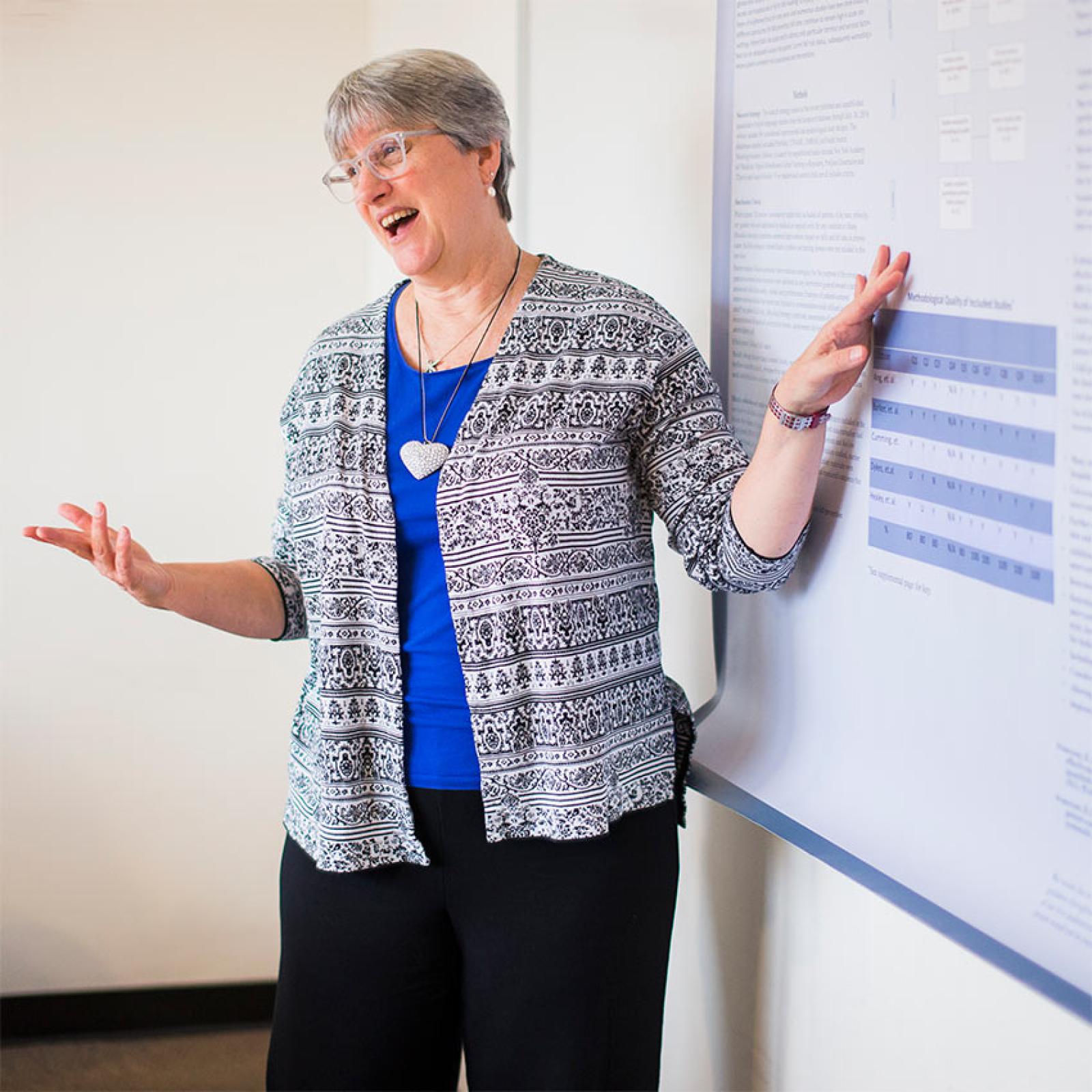 Professor from Pace University's College of Health Professions teaching at a whiteboard.