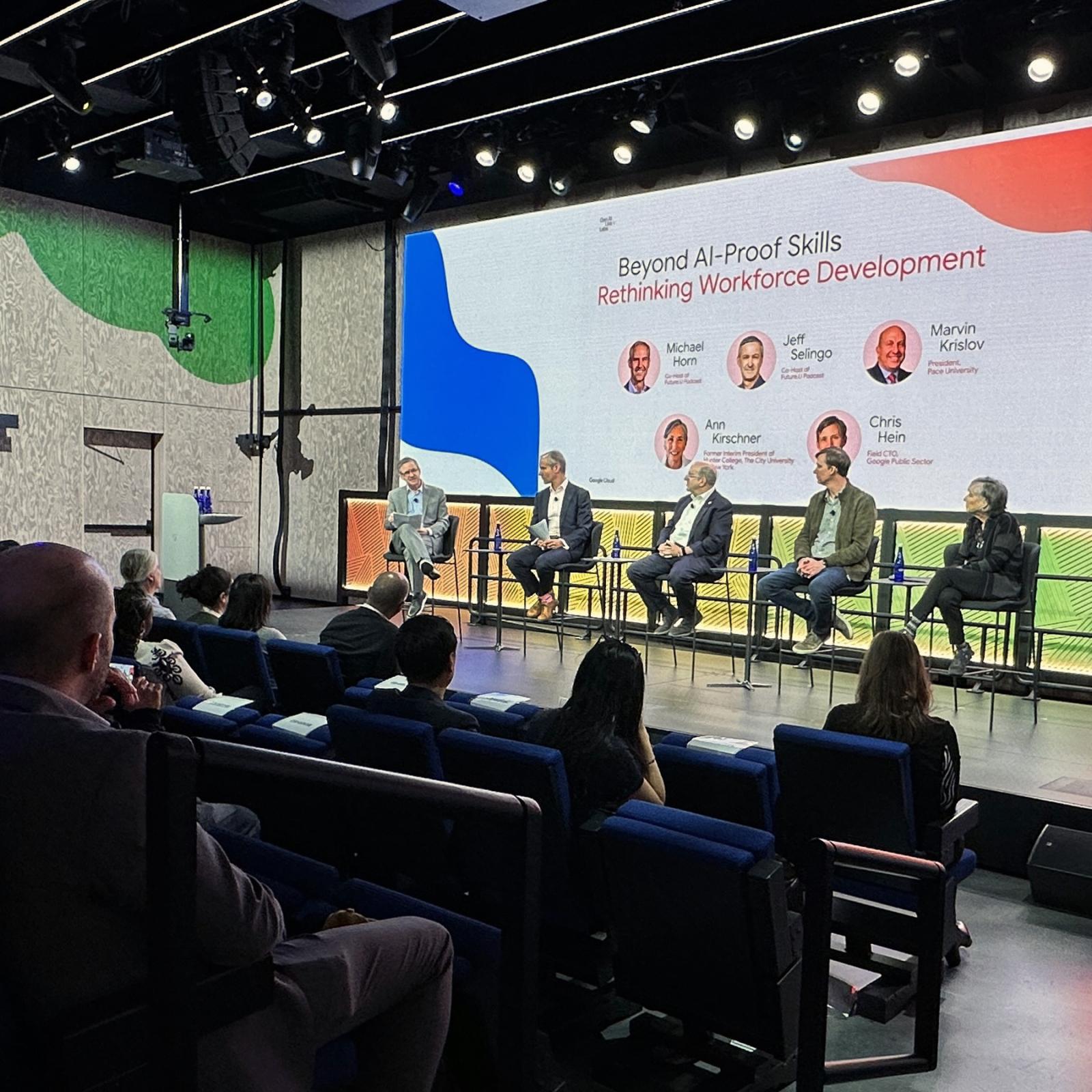 Marvin Krislov on stage with panelists in front of an audience.