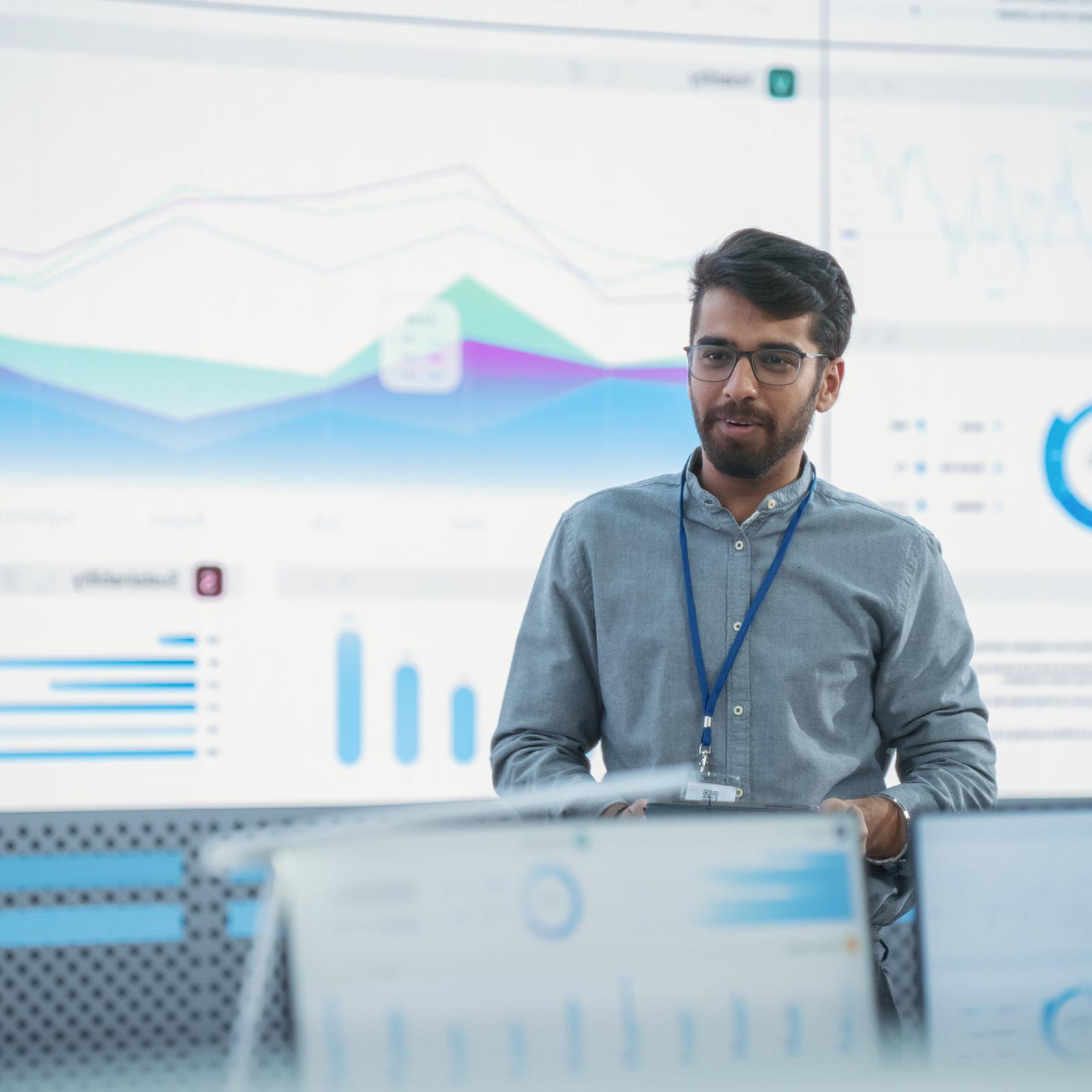 A young professional stands in a high tech office