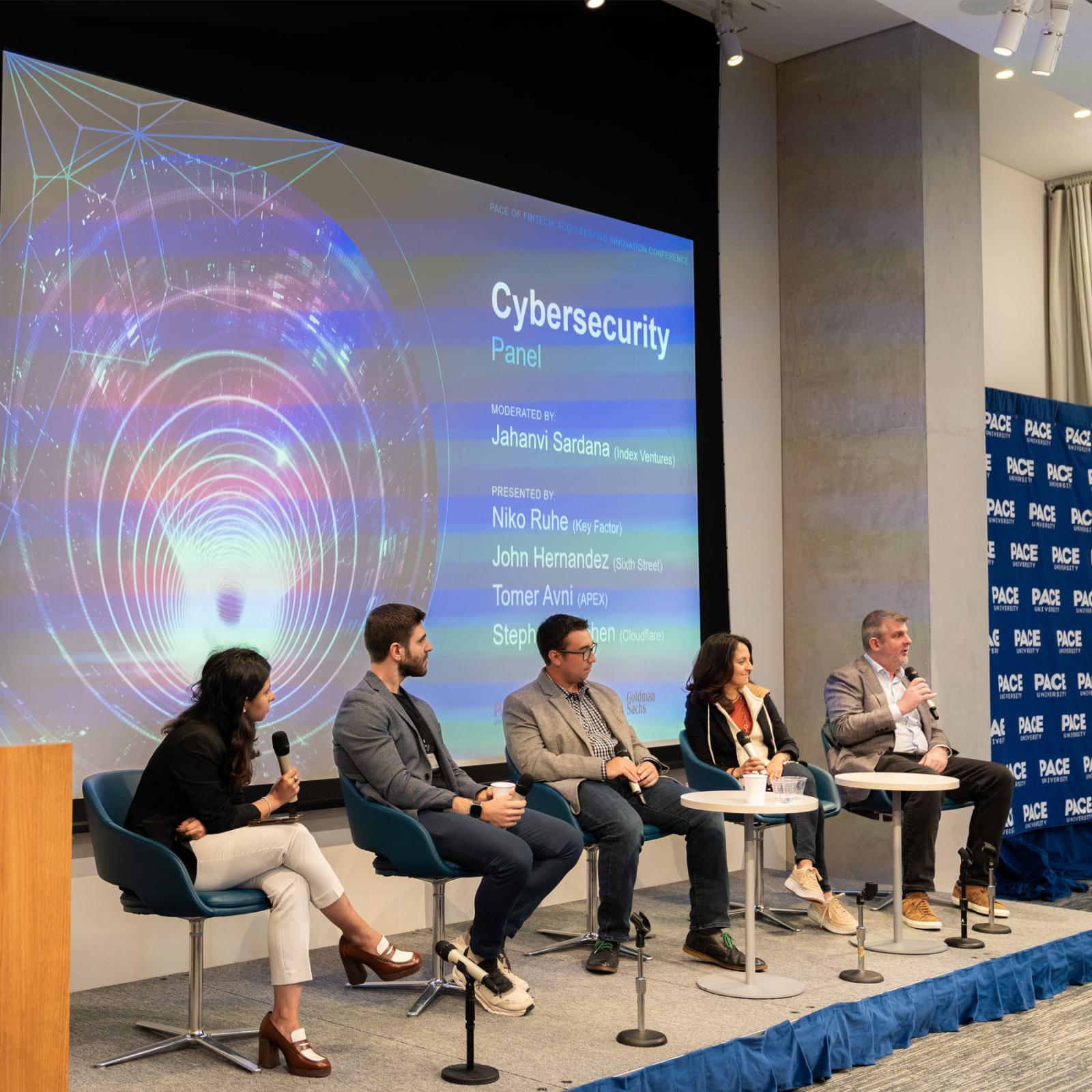 People on stage at a panel for the FinTech conference.