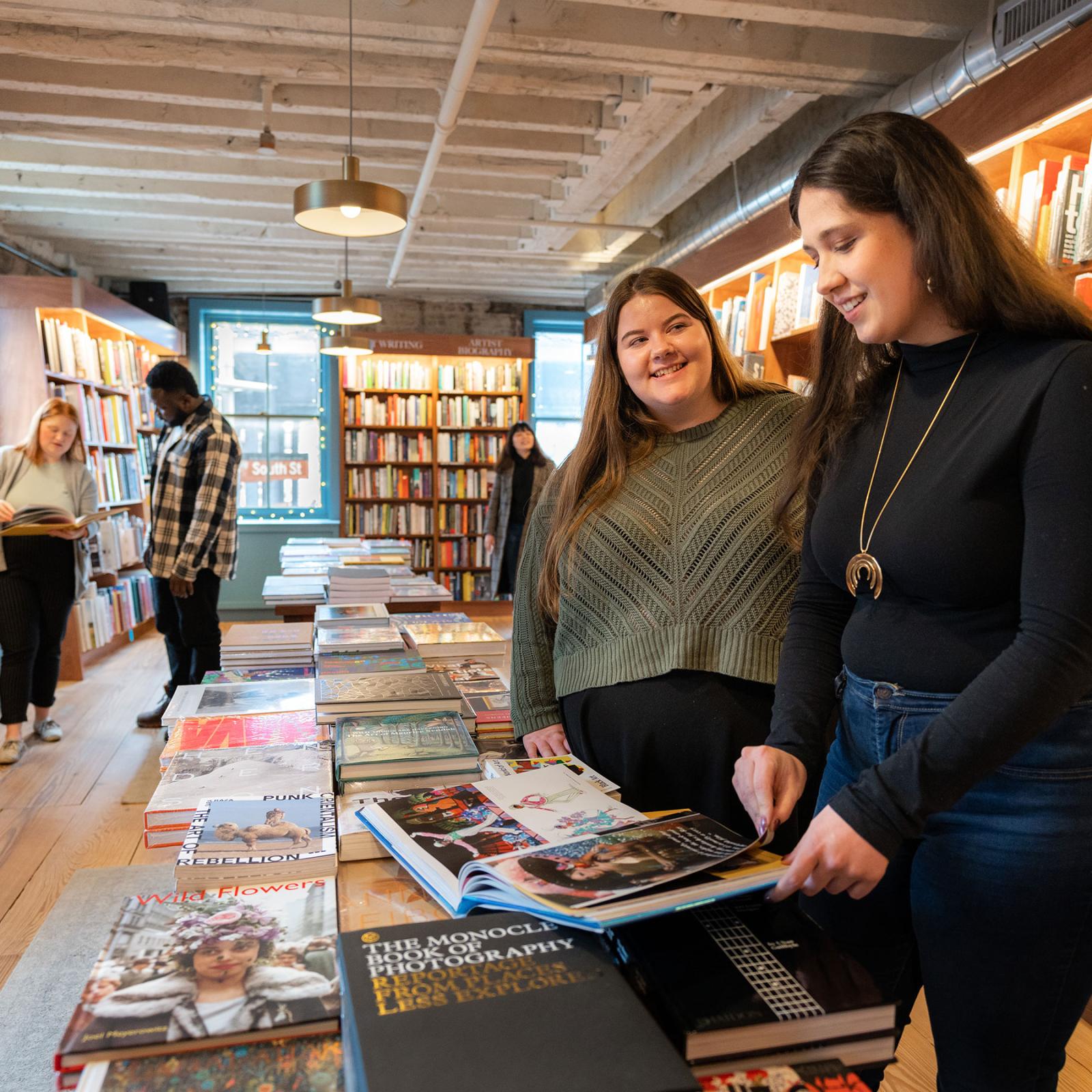 Pace University Publishing students looking at books together on a table in a bookstore