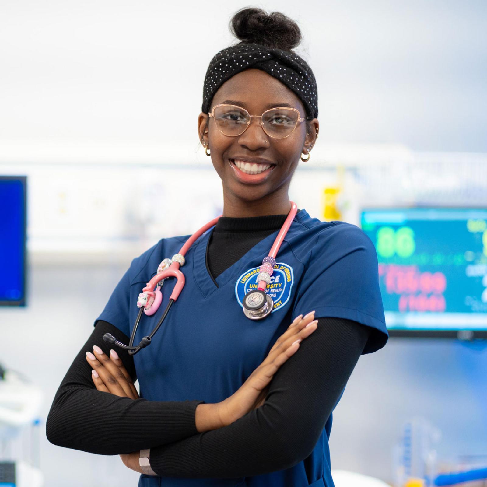 Nursing student in a classroom posing for the camera.