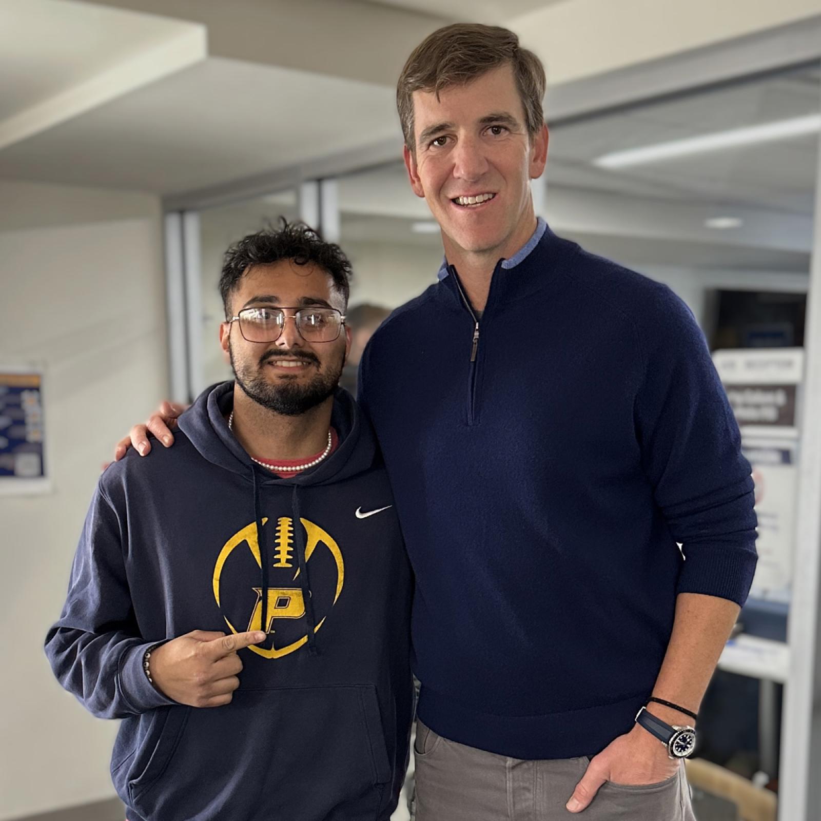 Eli Manning posing with Pace University student Rejos “Jose” Neopaney ’25