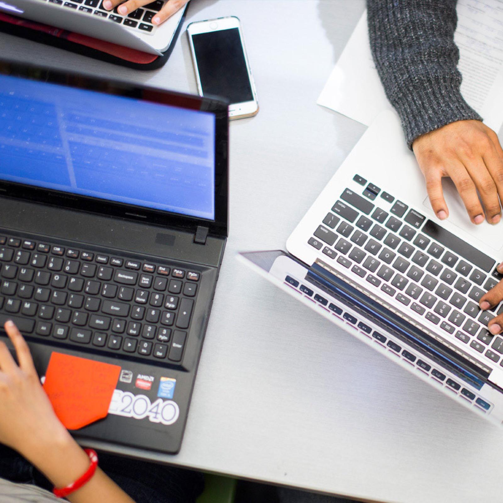 Overhead view of laptops and hands.