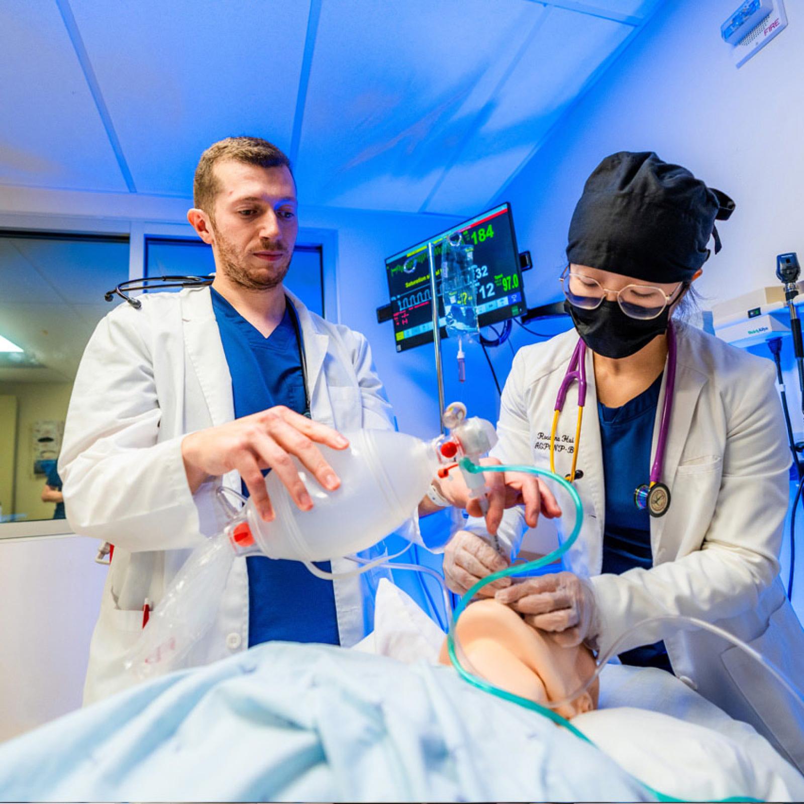 Pace University College of Health Professions Nursing students performing a procedure on a medical mannekin. 