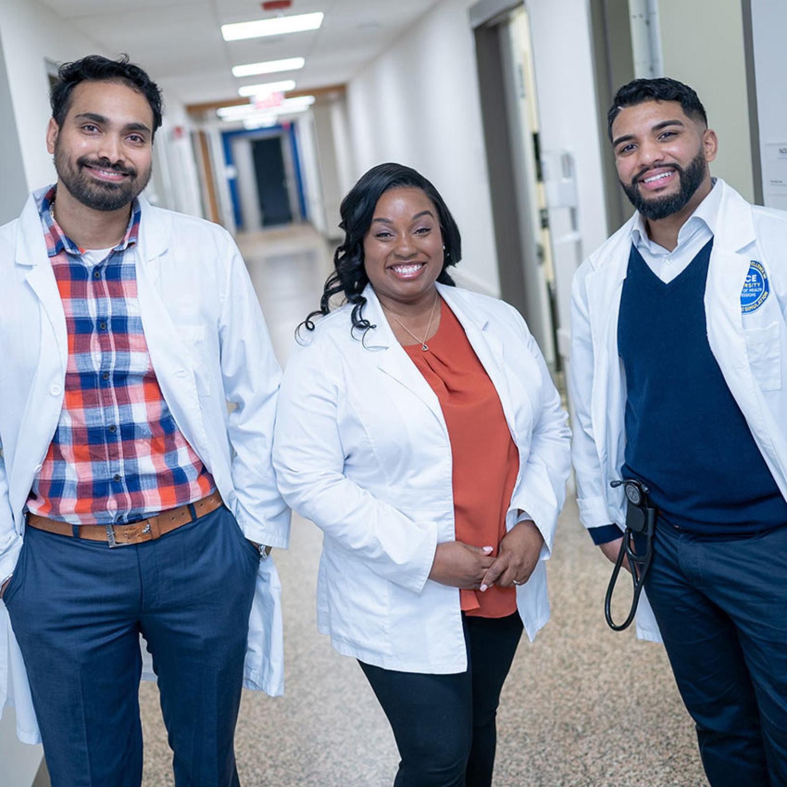 Three students from Pace University's College of Health Professions smiling for the camera.
