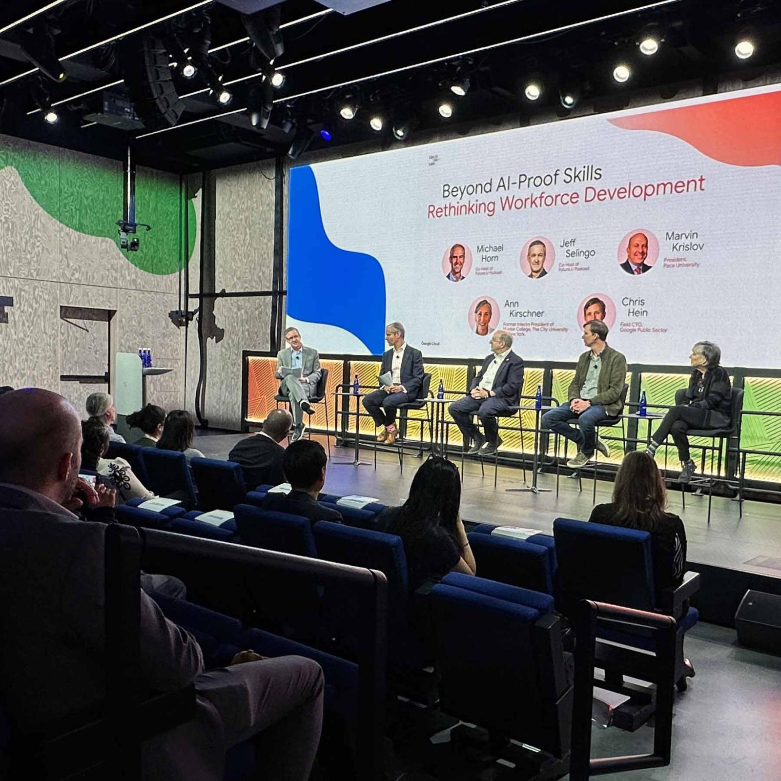 Marvin Krislov on stage with panelists in front of an audience.