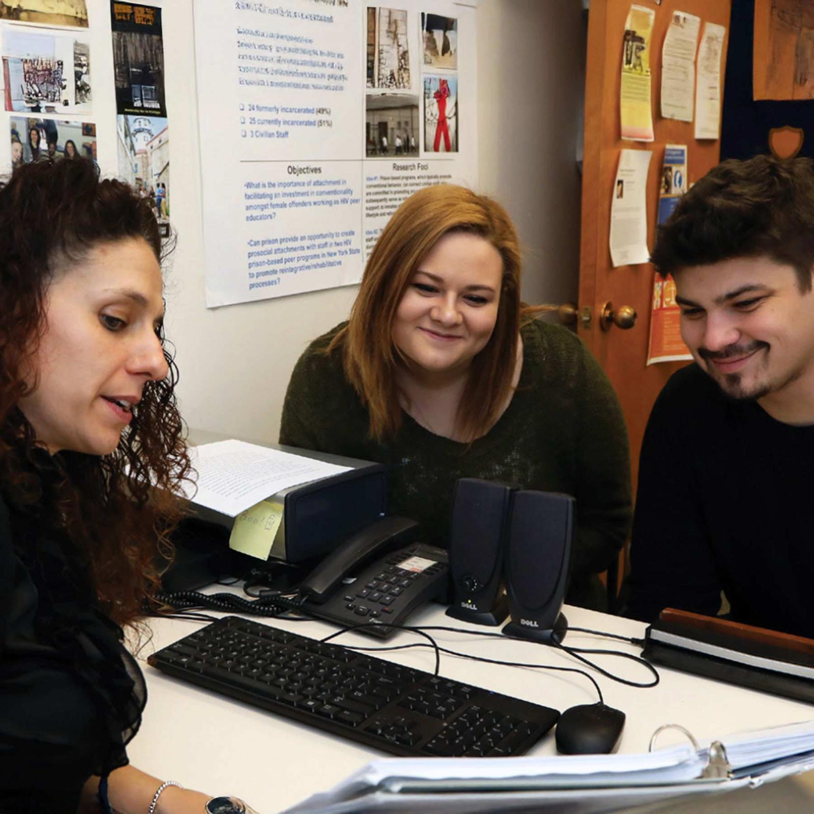 Pace University Director of Jail-Based Programs and Criminal Justice and Security professor Kimberly Collica-Cox showing a notebook to two students