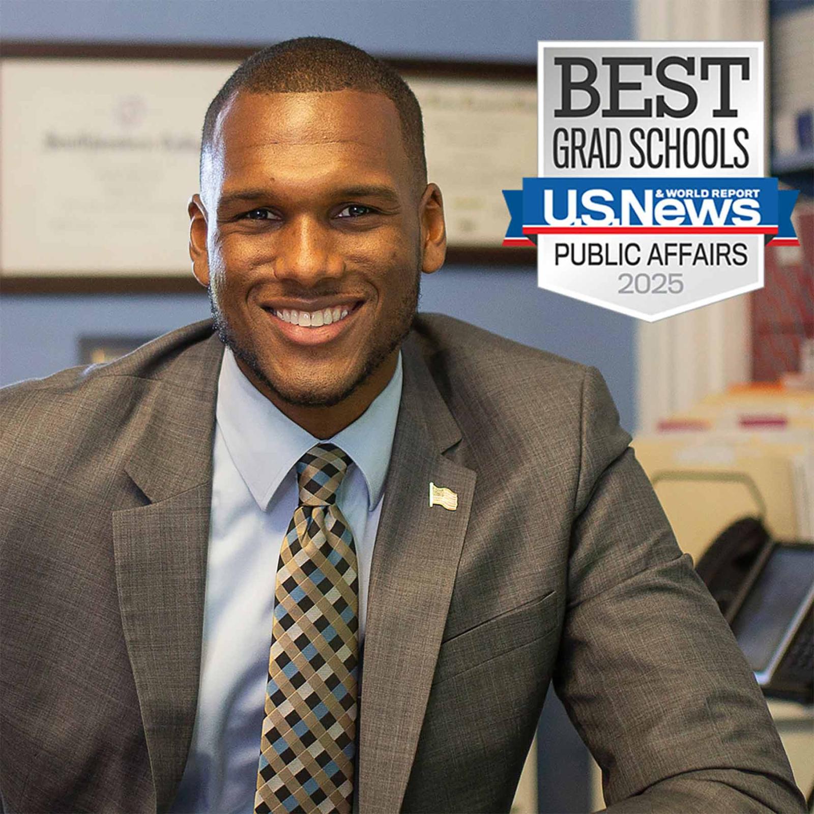 A male public administration graduate in an office with a badge from US News and World Report that says Best Grad Schools for Public Affairs